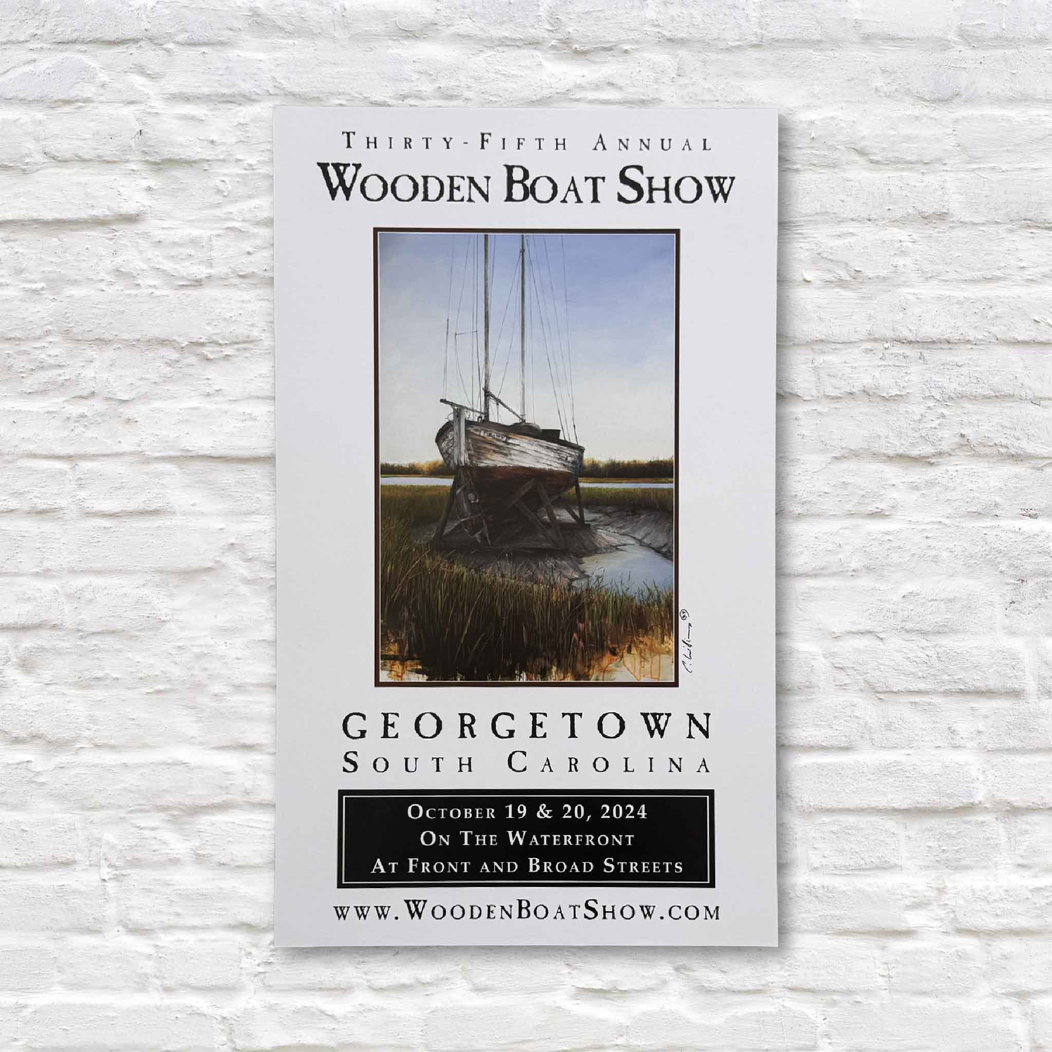 2024 Georgetown Wooden Boat Show poster featuring a sailboat resting in the marsh, artwork by Charles Williams, signed by the artist.