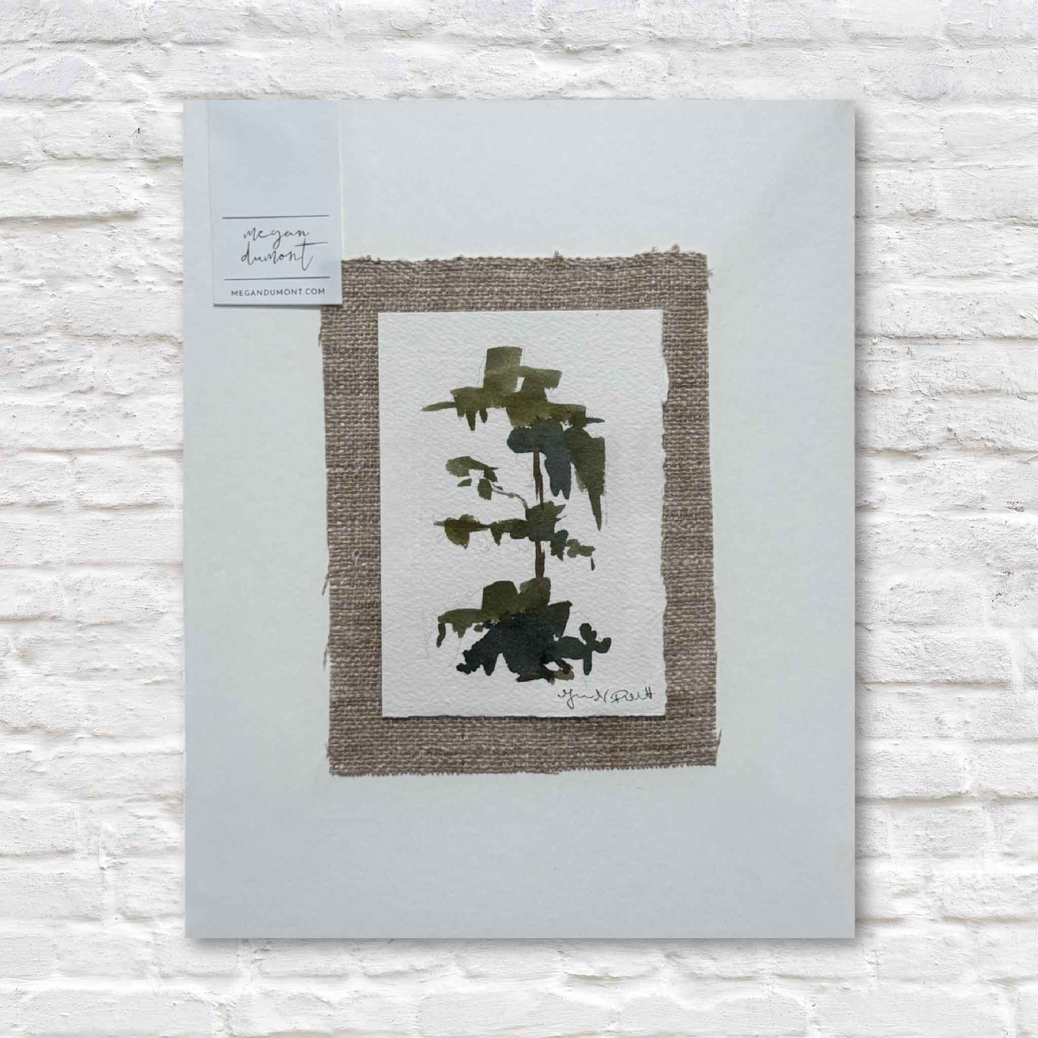 Framed abstract tree artwork on a textured white wall