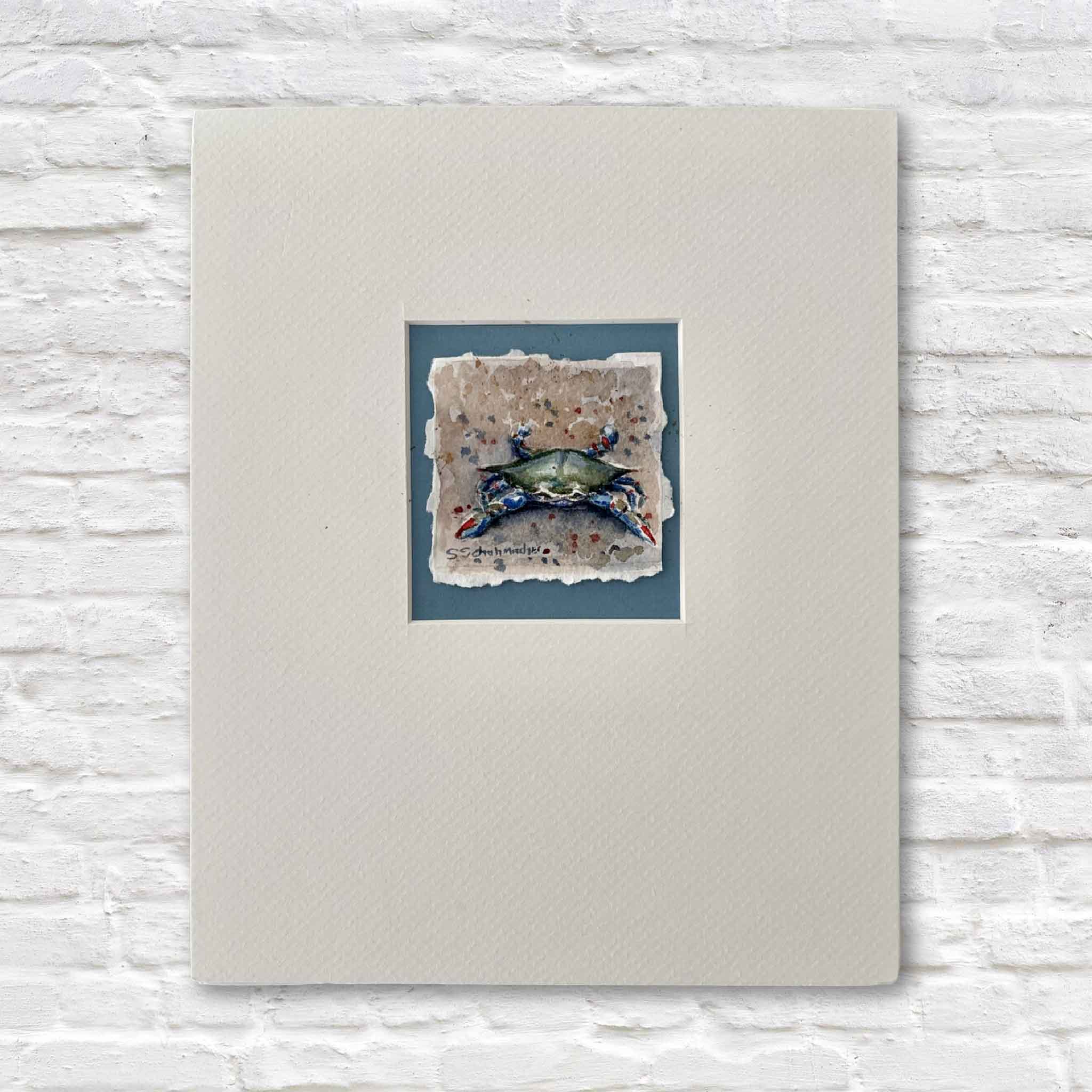 Matted original watercolor artwork of a crab on textured paper with a white background by a local artist