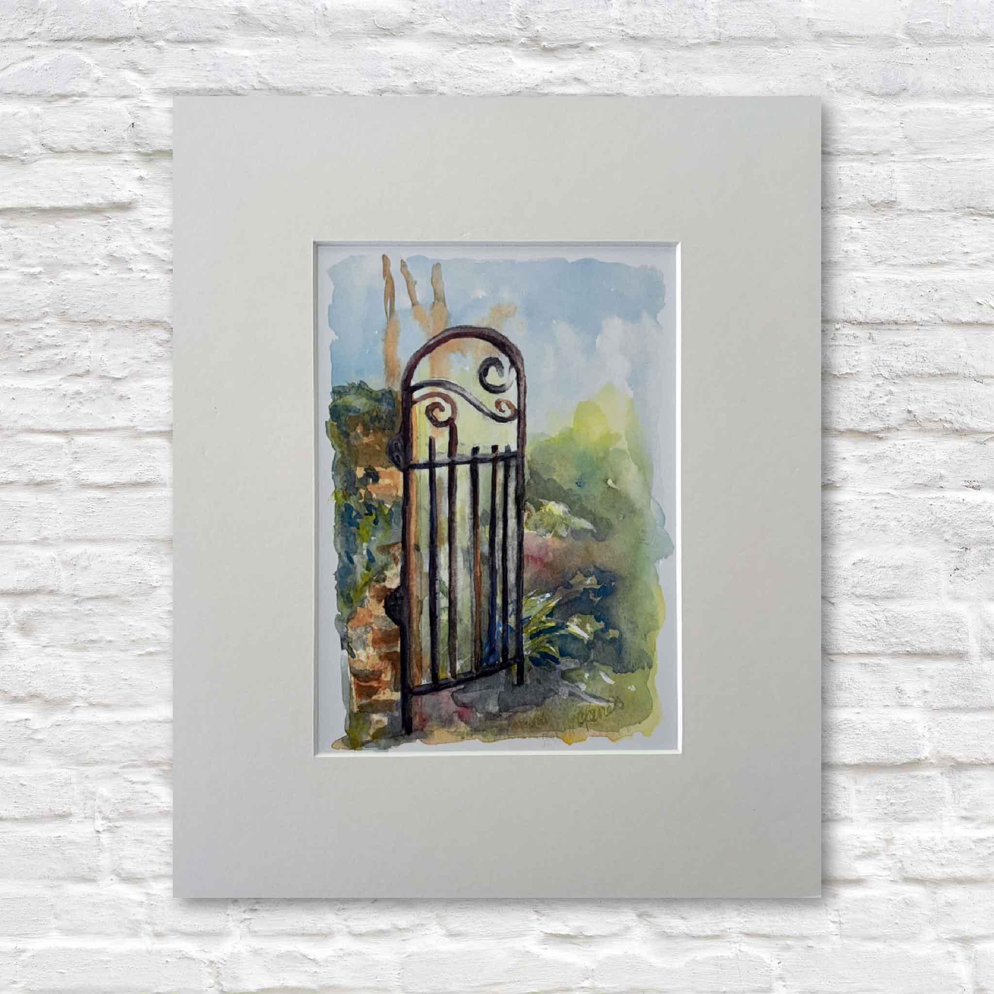 matted watercolor painting of a gate on a white brick wall