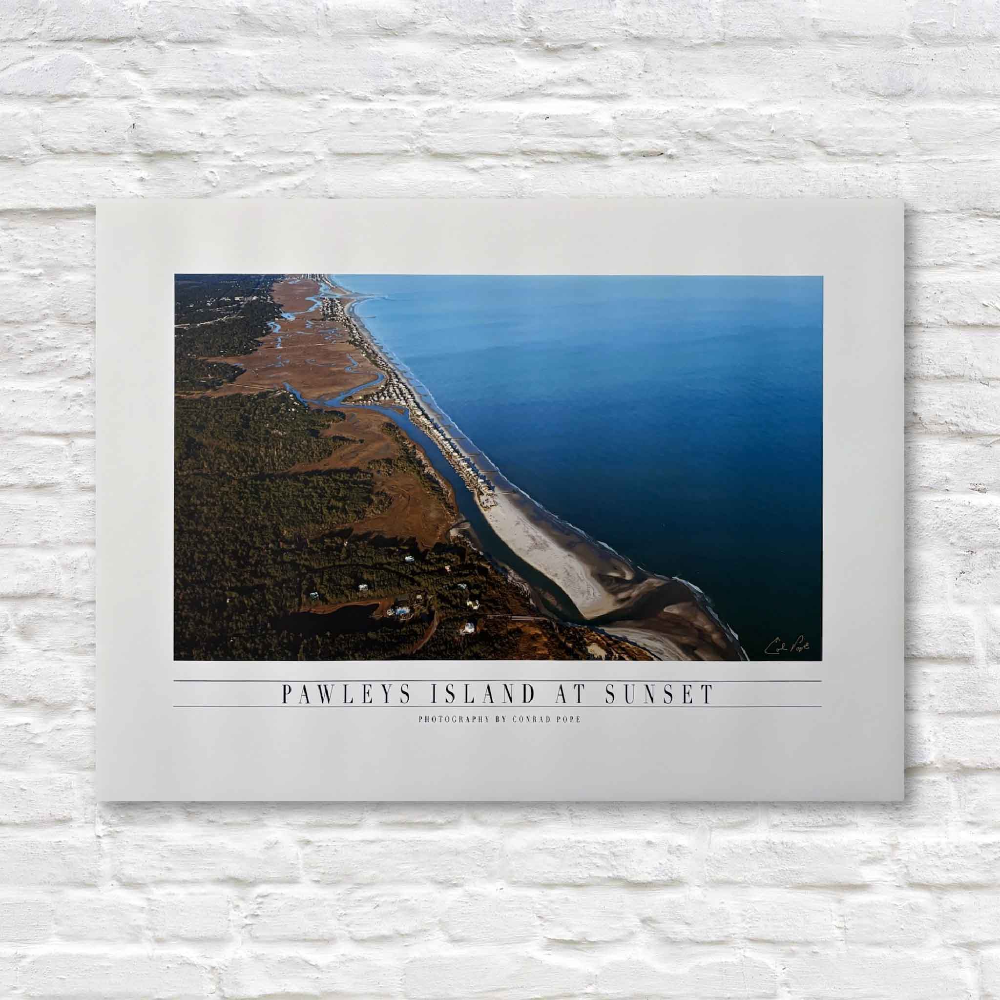 aerial photograph of Pawleys Island at sunset on a white brick wall.