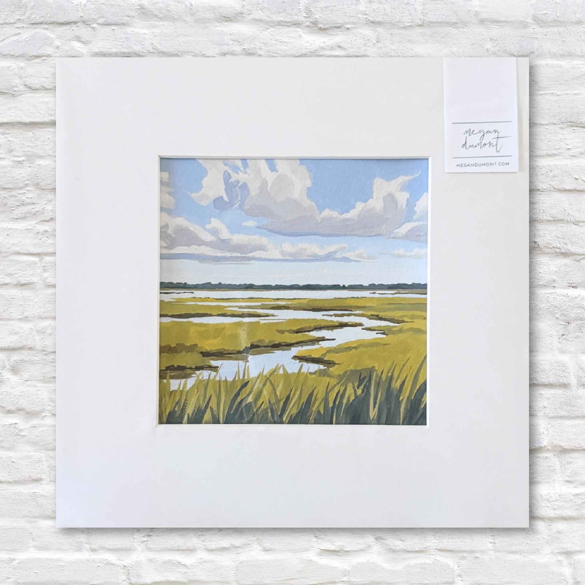 Matted artwork of a marsh landscape with a white border on a textured white surface.