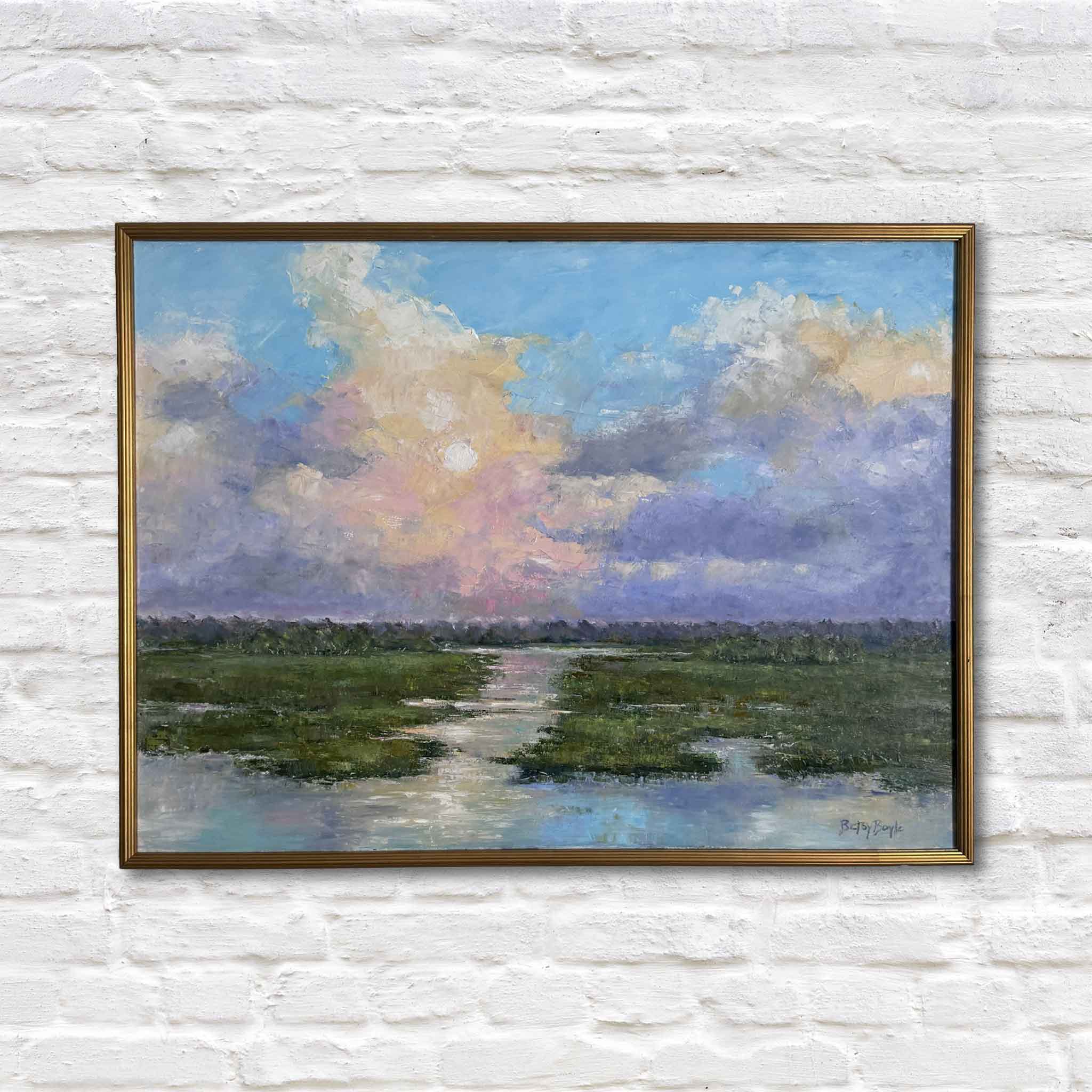 original framed artwork of lowcountry marsh hanging on a white brick wall