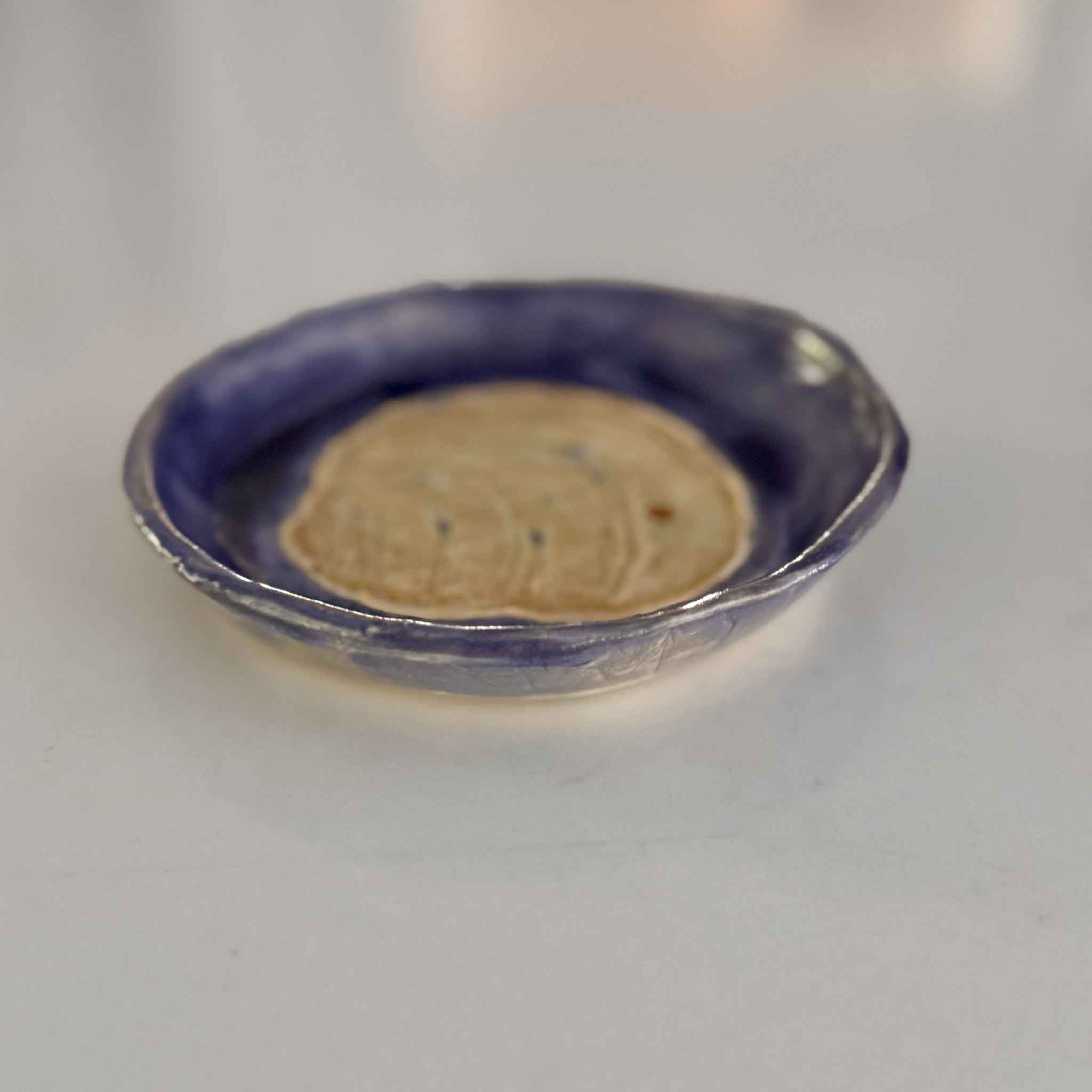 blue pottery dish with pawleys island shell in center