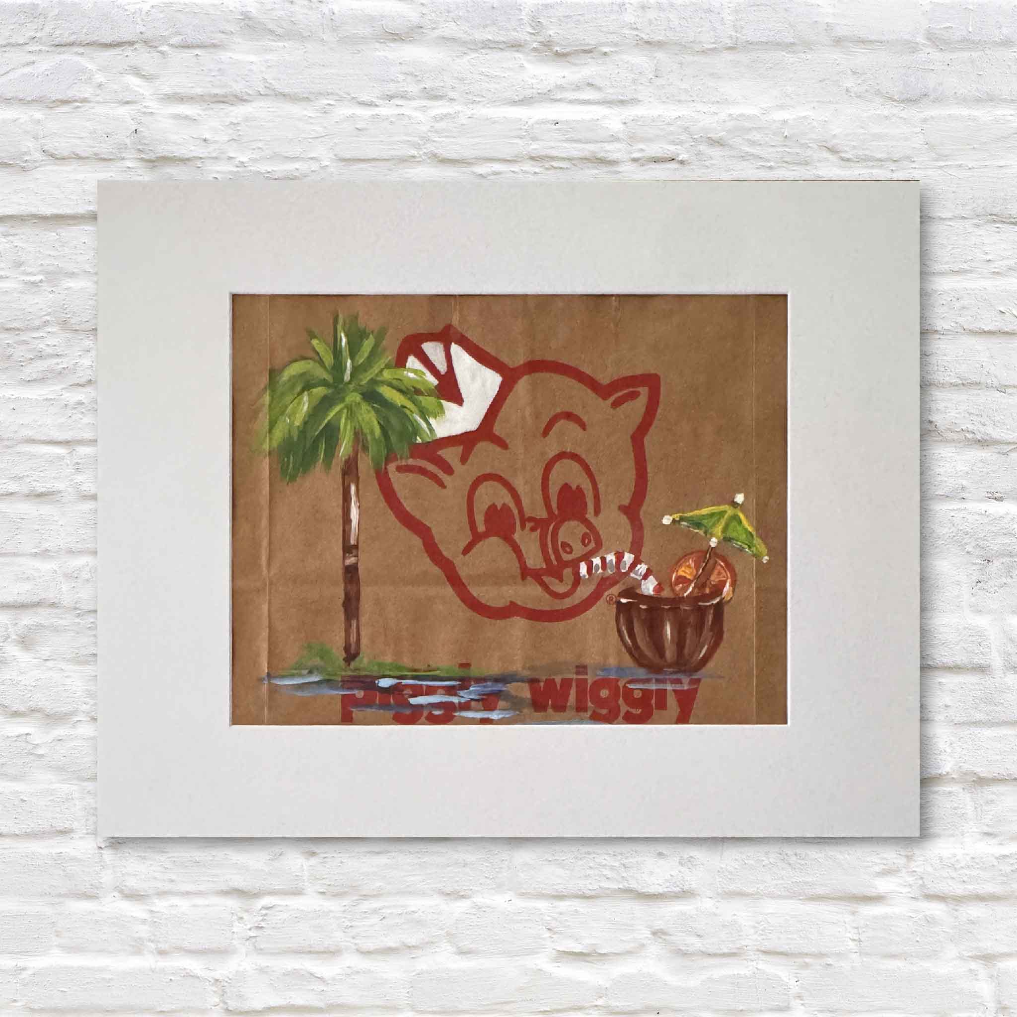 Mixed media artwork of acrylic painting of a pina colada and palm tree on a Piggly Wiggly shopping bag in a white matte against a white brick wall