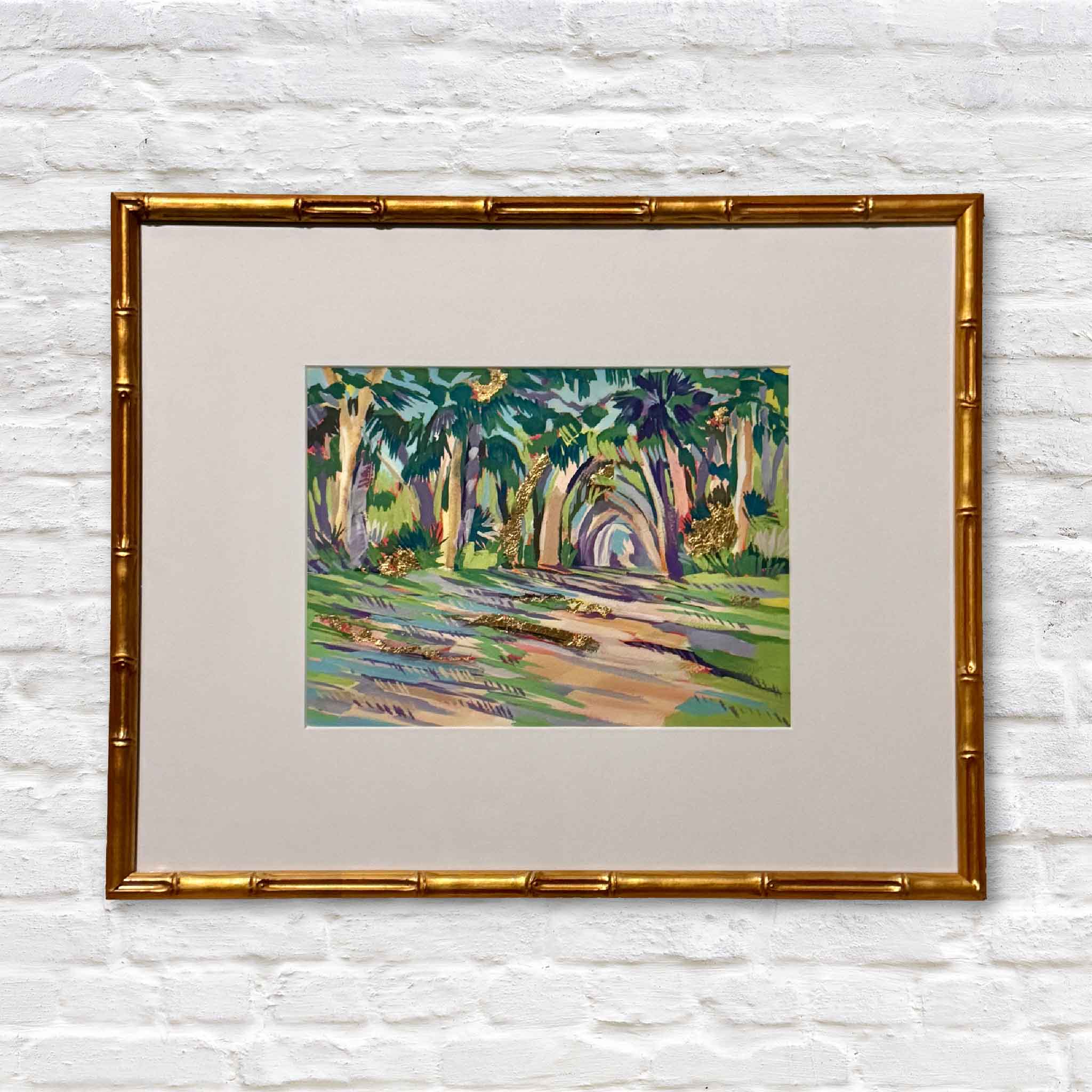 Bamboo gold framed mixed media artwork of colorful lowcountry trees on a white brick wall
