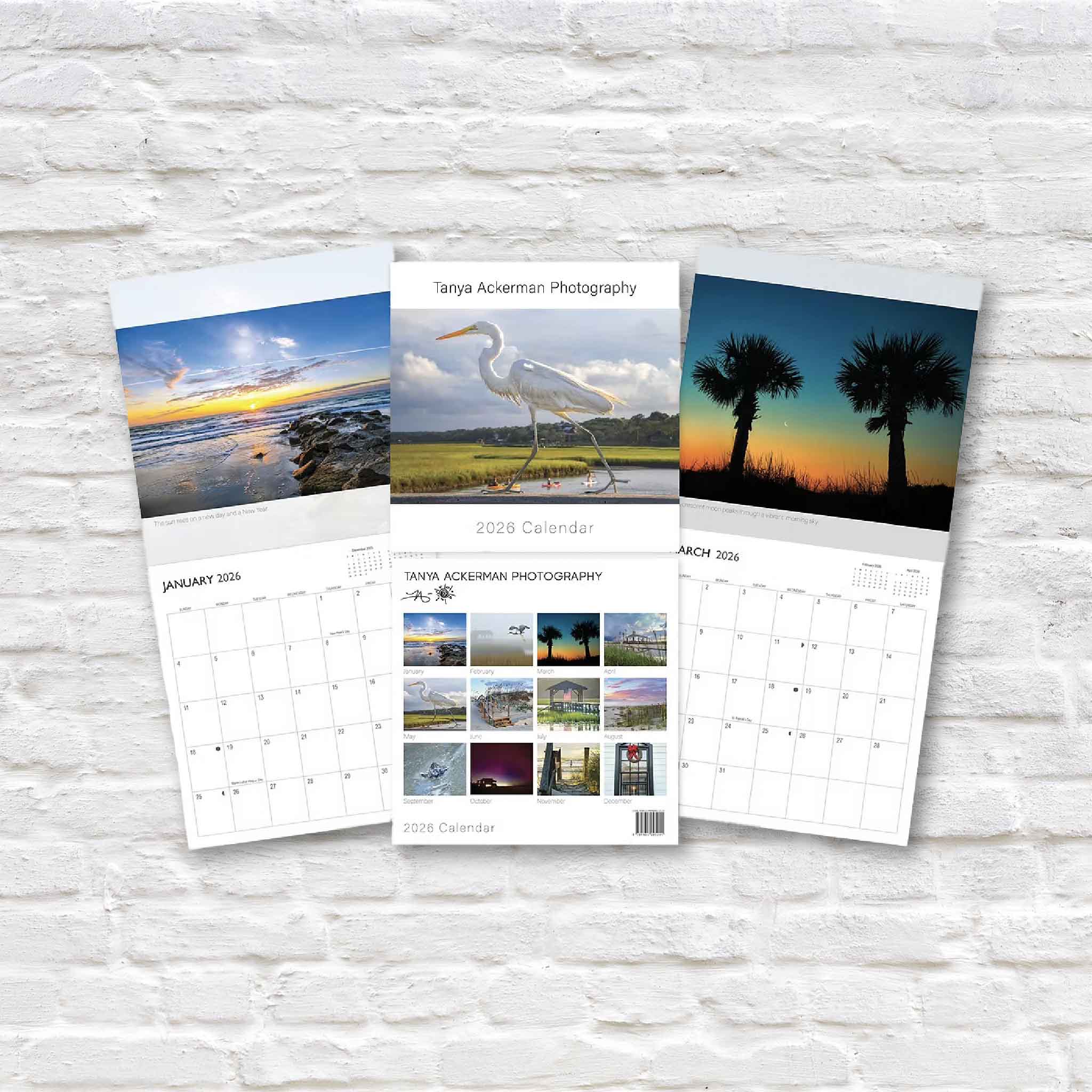 Photography of Pawleys Island calendars open against a white brick wall.