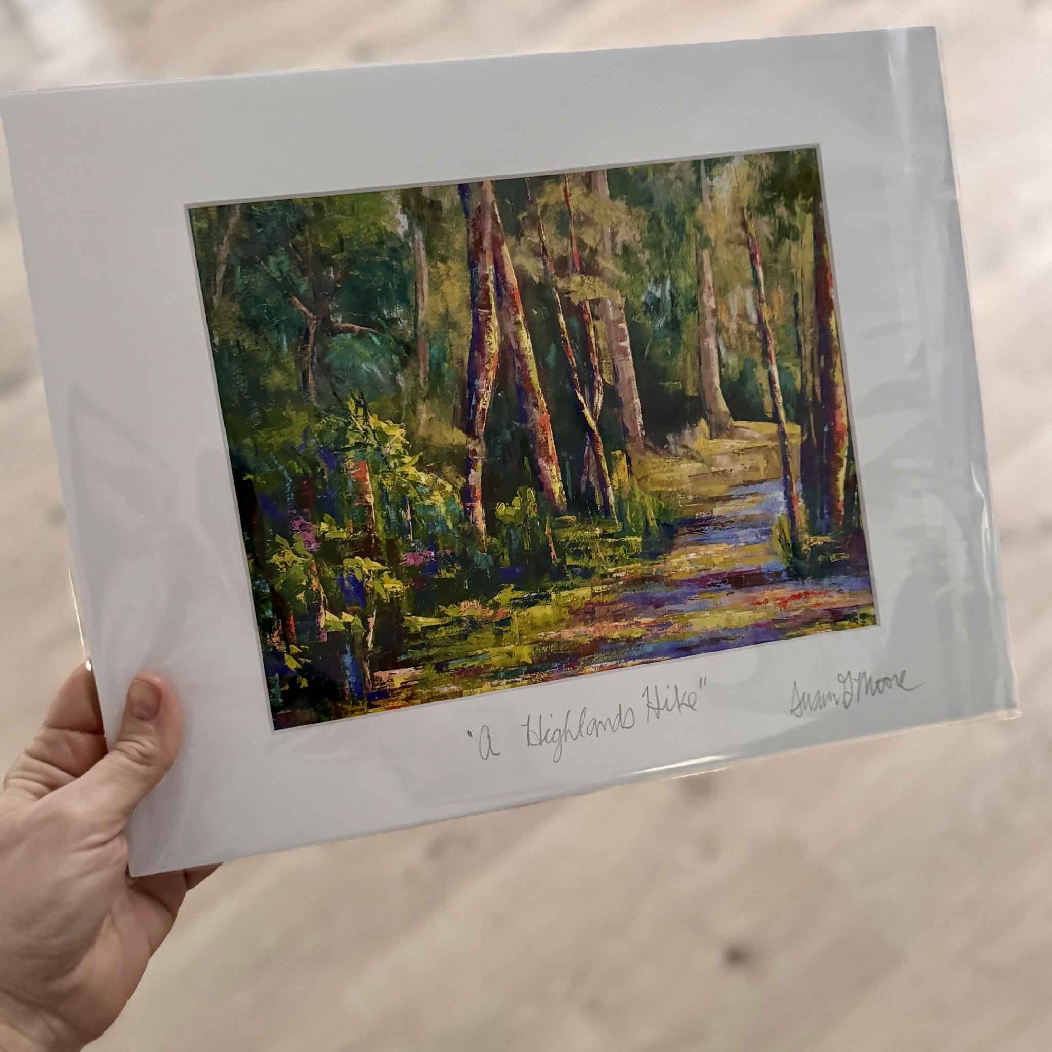 14x11 matted fine art giclée print A Highlands Hike by Susan Moore featuring a sunlit woodland trail painted in rich greens, violets, and golds.