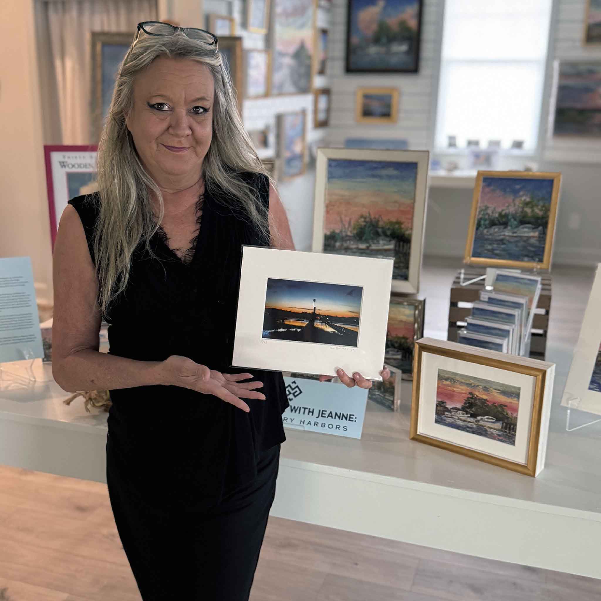 Charlotte holding the matted 8x10 Carolina #116 coastal sunset photograph at Gray Man Gallery.