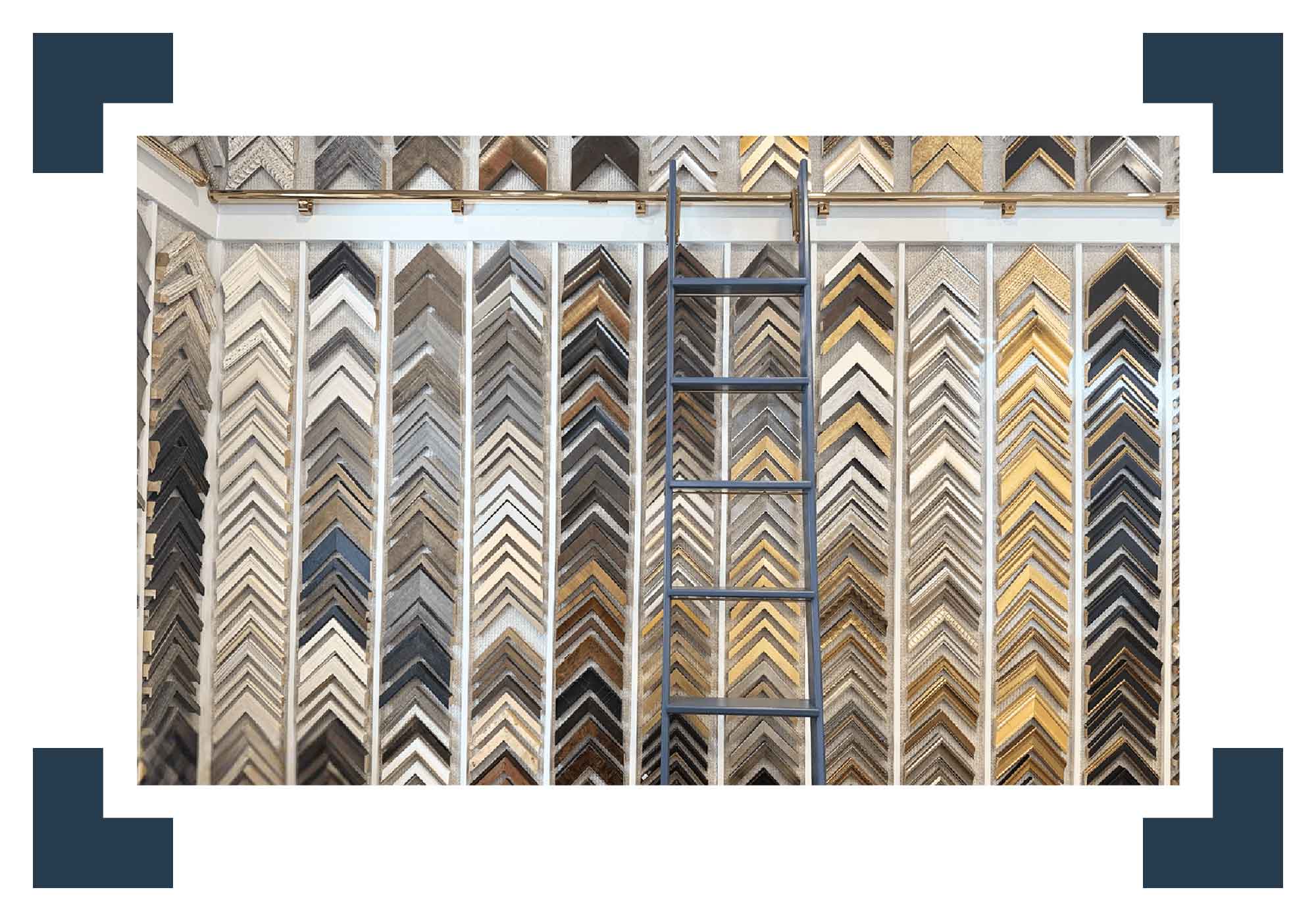 Display of various wooden picture frames with a ladder in the middle.