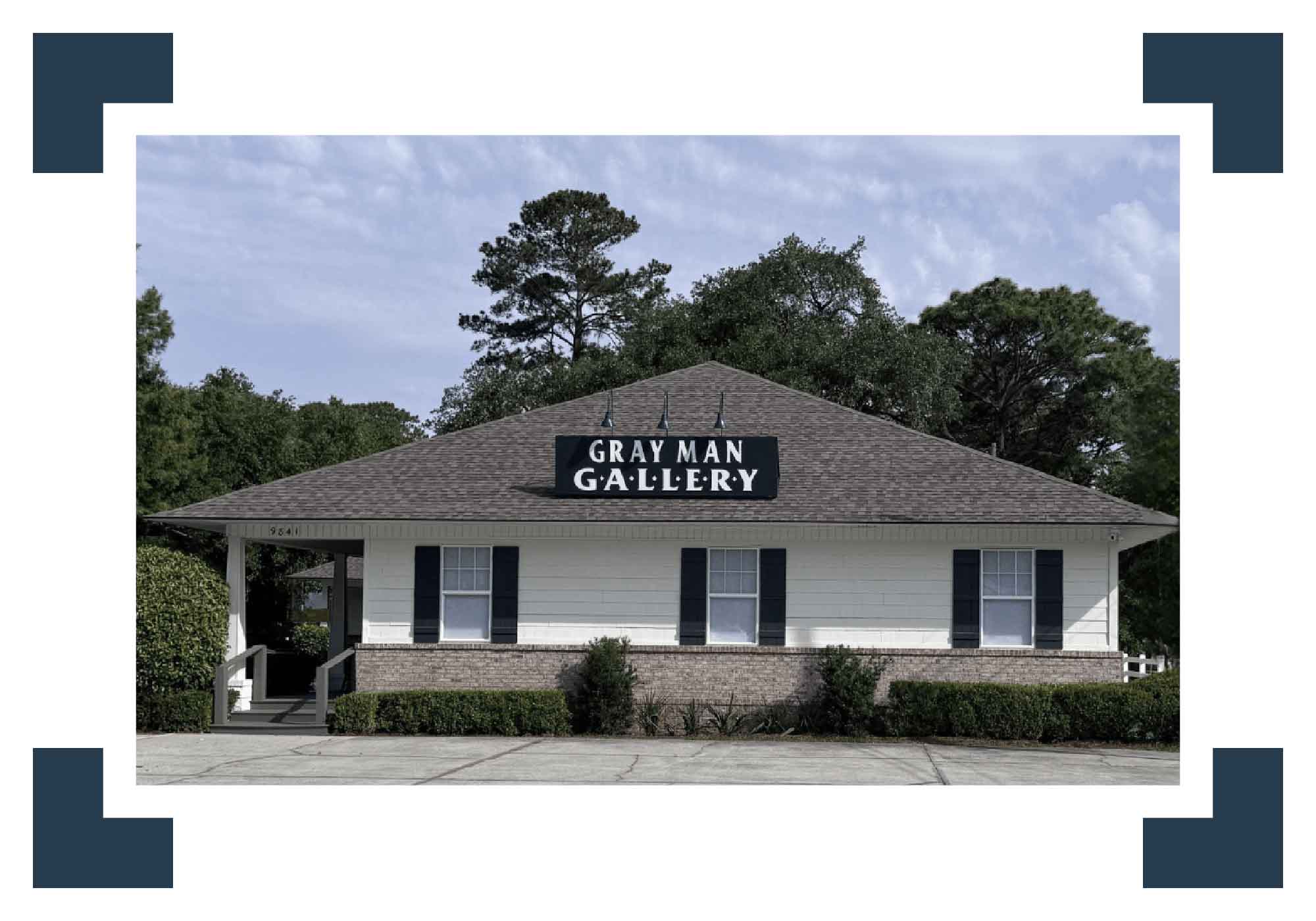 Gray Man Gallery building with trees in the background