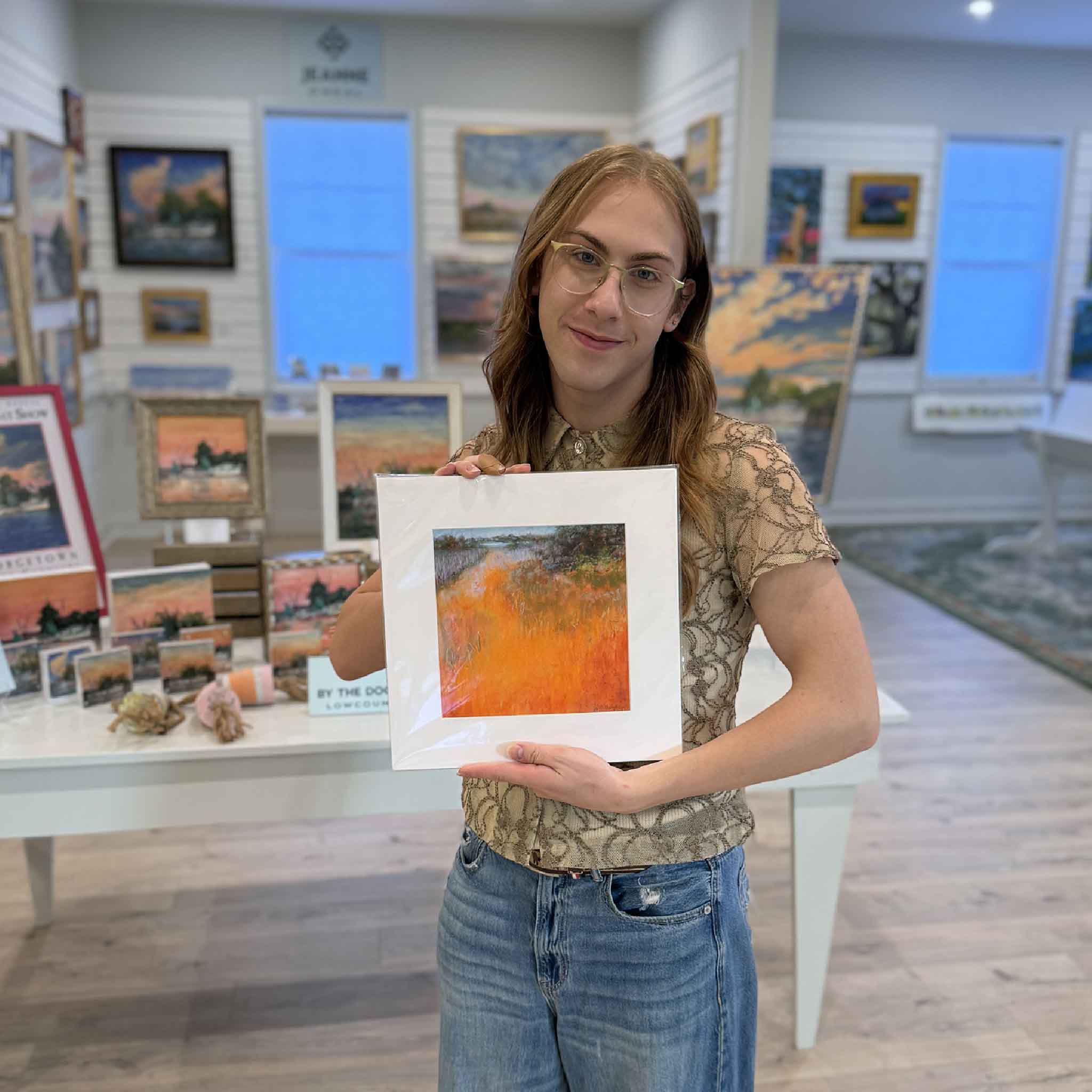 “Heating Up” pastel print by Joanne Willoughby, matted to 12×12 with vibrant orange marsh grasses and coastal landscape. Pictured at Gray Man Gallery.
