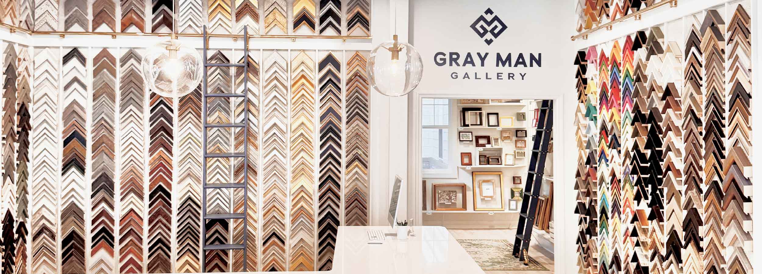 Display of various picture frames with 'Gray Man Gallery' branding.