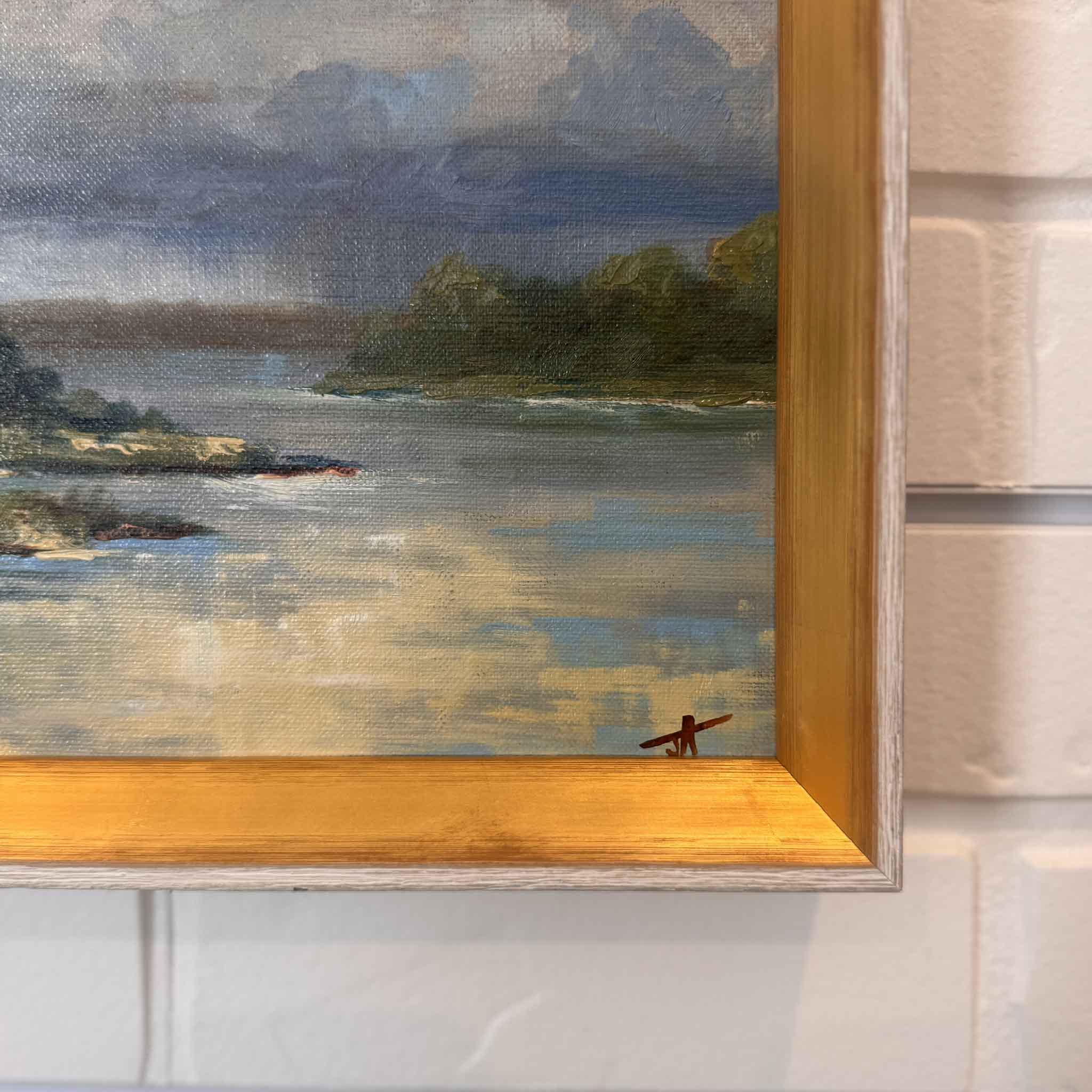 Framed oil painting Clearing Skies by meteorologist Jamie Arnold, featuring sunlight over a Lowcountry marsh with rain clouds in the distance.