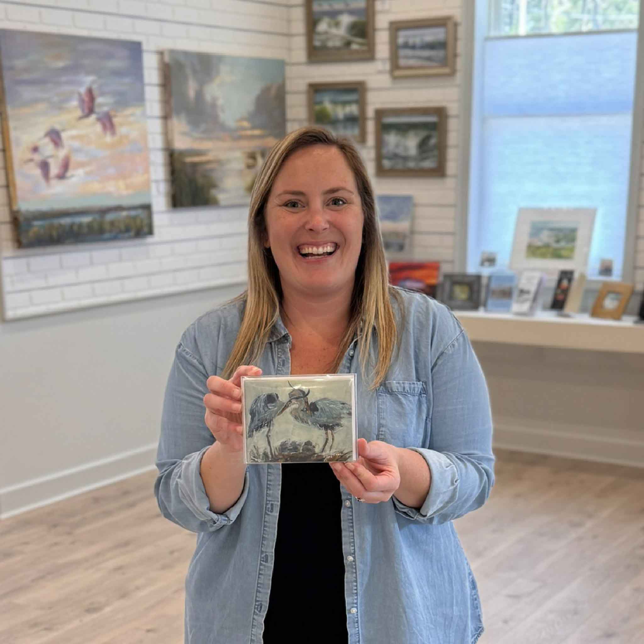 Gray Man Gallery team member holding The Family blue heron notecard set featuring artwork by local Pawleys Island artist Jeanne O’Neal, a set of five blank coastal notecards available at Gray Man Gallery in Pawleys Island South Carolina