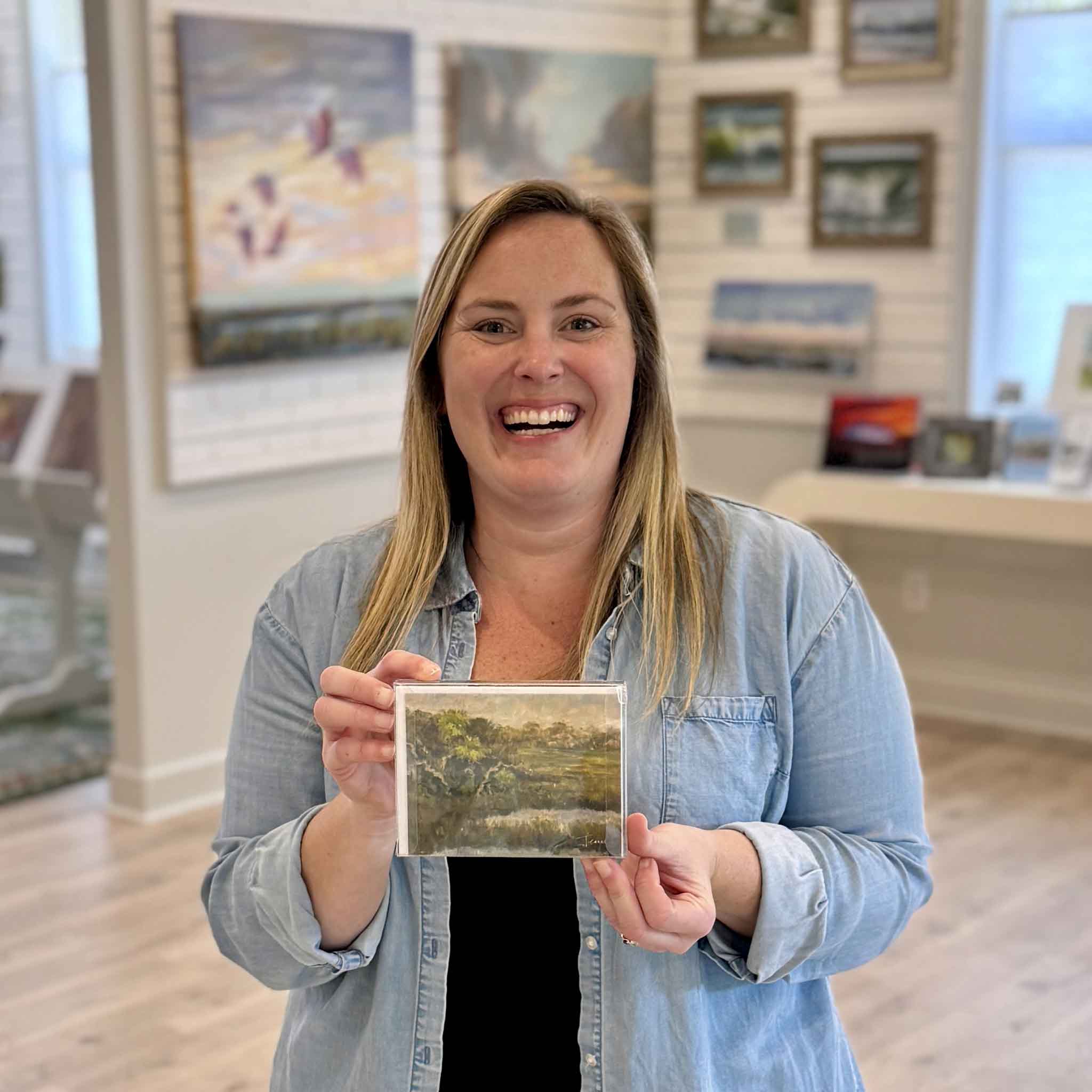 Gray Man Gallery team member holding Marsh Reflections notecard set featuring Lowcountry marsh artwork by local Pawleys Island artist Jeanne O’Neal available at Gray Man Gallery