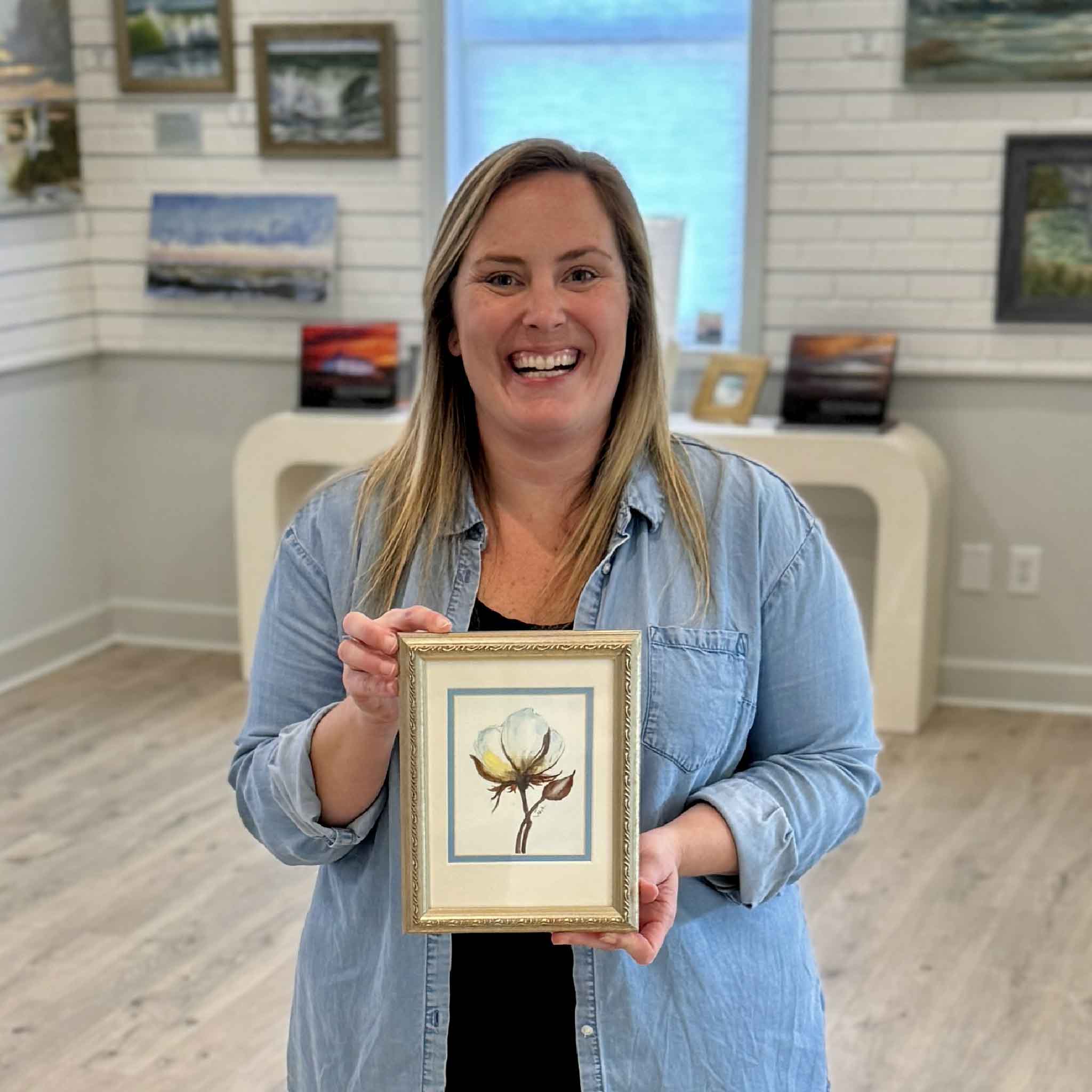 Bordy holding Southern Comfort, an original cotton bloom watercolor painting by Pawleys Island local artist Vida Miller, double-matted and framed artwork available at Gray Man Gallery in Pawleys Island South Carolina