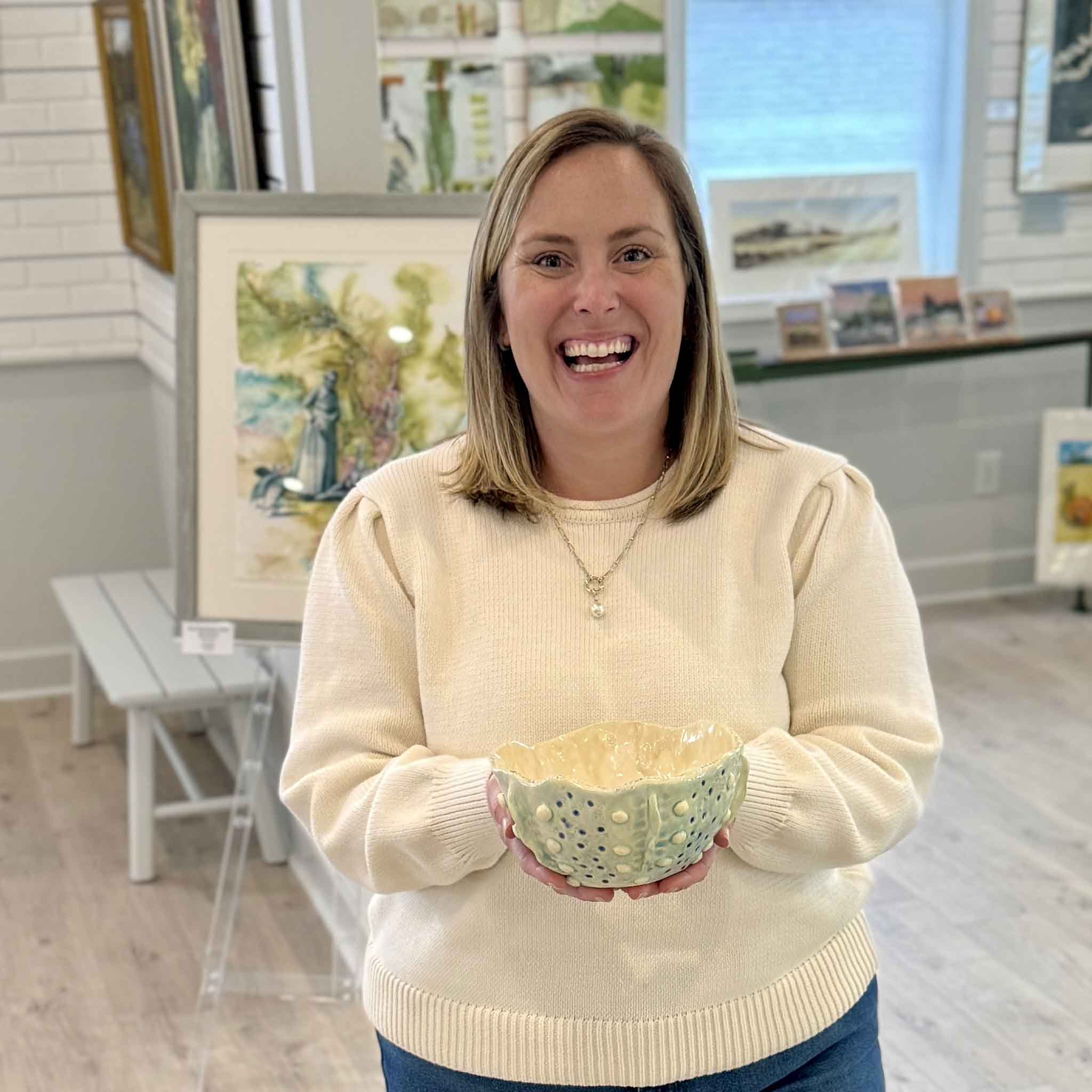 Bordy holding Tidepool Texture Bowl by local artist Vida Miller inside Gray Man Gallery Pawleys Island showing scale and sculptural ceramic form