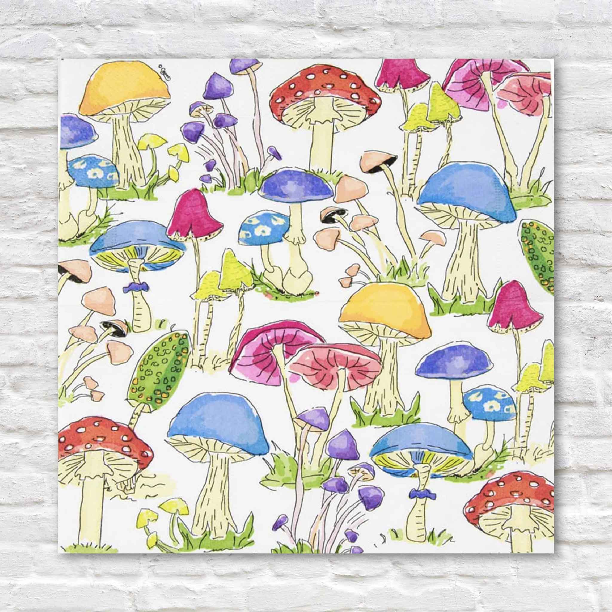 Caspari Woodland Mushrooms cocktail napkins featuring a colorful watercolor pattern of whimsical red, blue, yellow, purple, and pink mushrooms. These premium triple-ply paper napkins bring playful woodland charm to fall entertaining, holiday gatherings, dinner parties, baby showers, and everyday table settings. Available at Gray Man Gallery in Pawleys Island, South Carolina.