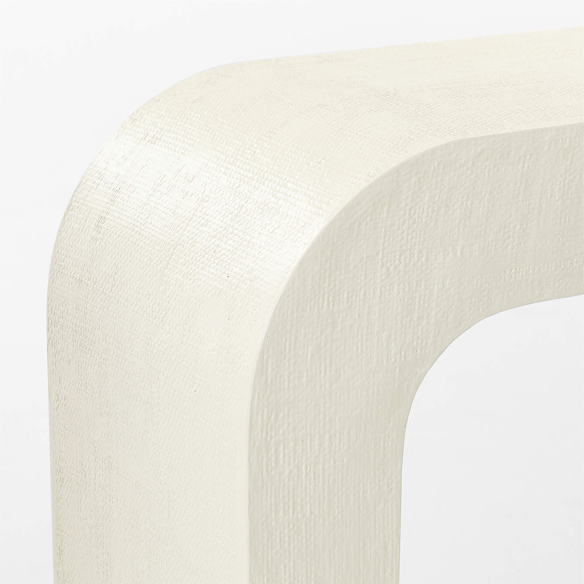 Closeup detail of CB2 Crescent console table ivory resin surface showing raffia inspired texture and handcrafted material variation designed by Ceci Thompson for CB2