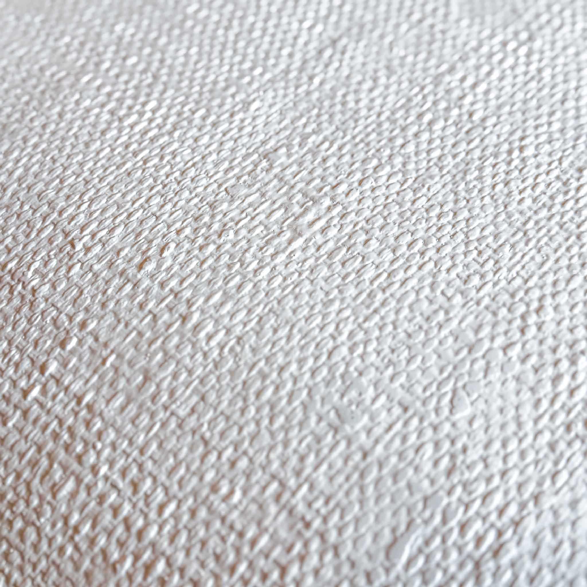 Macro closeup of textured ivory resin and fiberglass composite surface on CB2 Crescent console table showing raffia inspired material detail and handcrafted variation