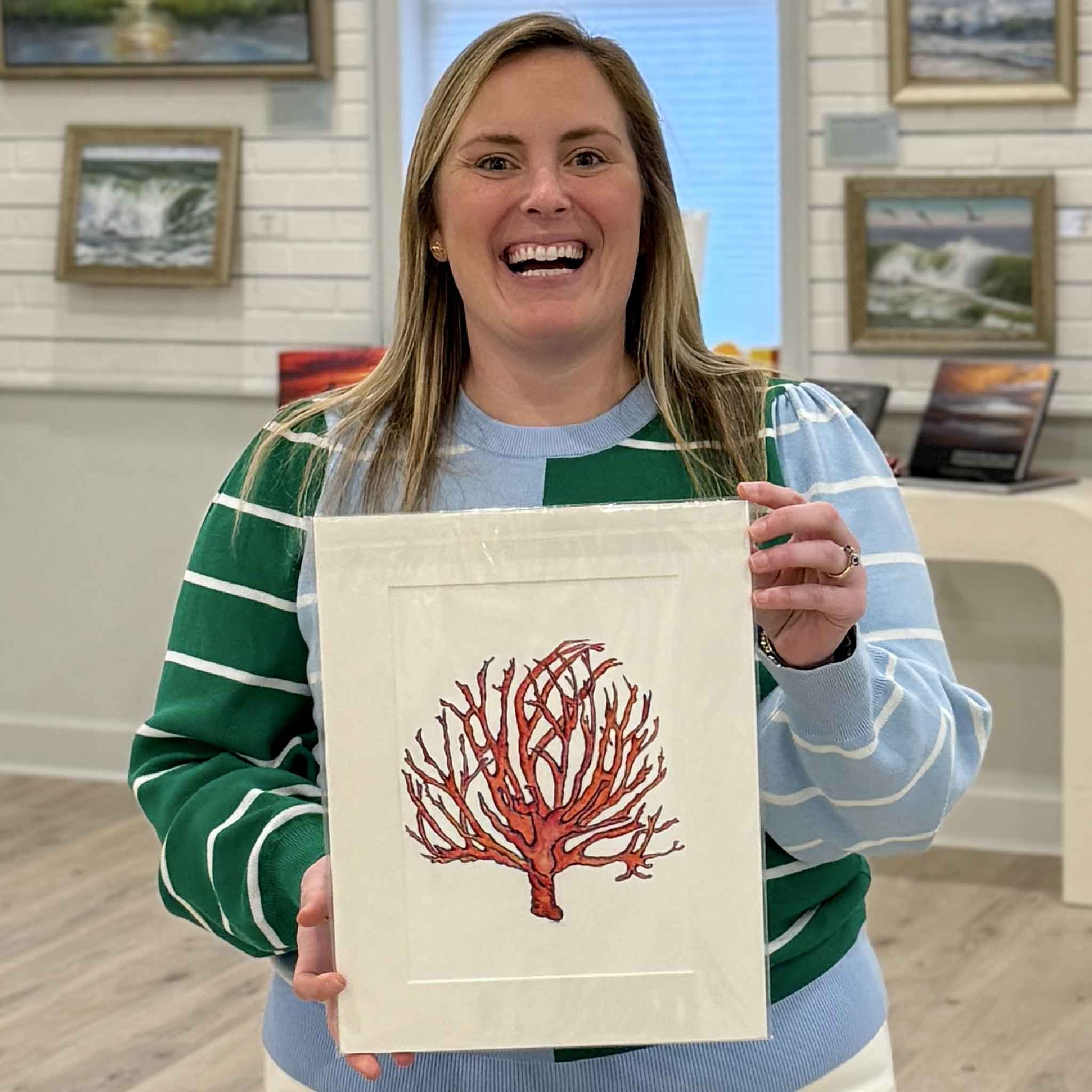 Bordy holding Coral Study II fine art giclée print by local artist Jeanne O’Neal, matted to fit an 11x14 frame at Gray Man Gallery in Pawleys Island