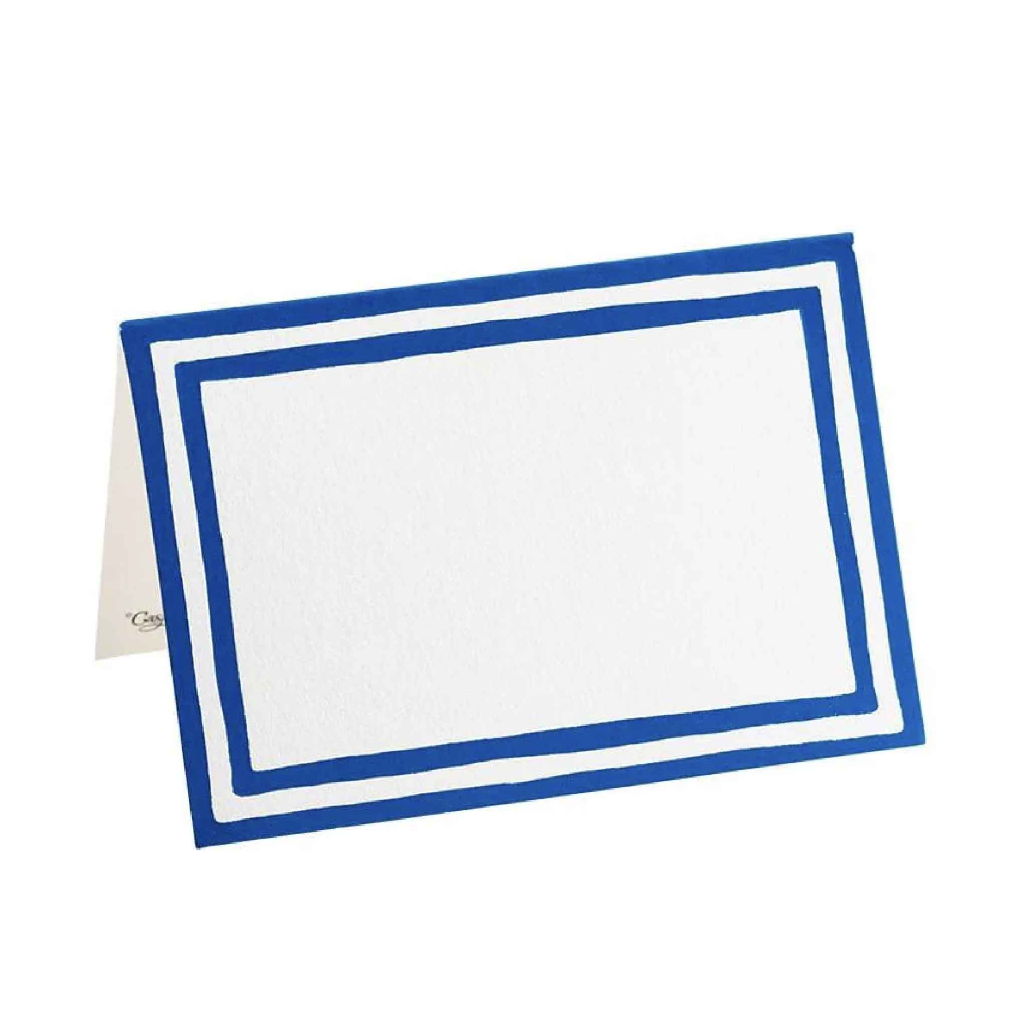 Single Caspari Stripe Border Blue folded place card standing upright, showing the classic blue border and generous blank space for handwritten guest names, menu labels, or seating assignments. Premium cardstock printed in the USA and available at Gray Man Gallery in Pawleys Island, South Carolina.