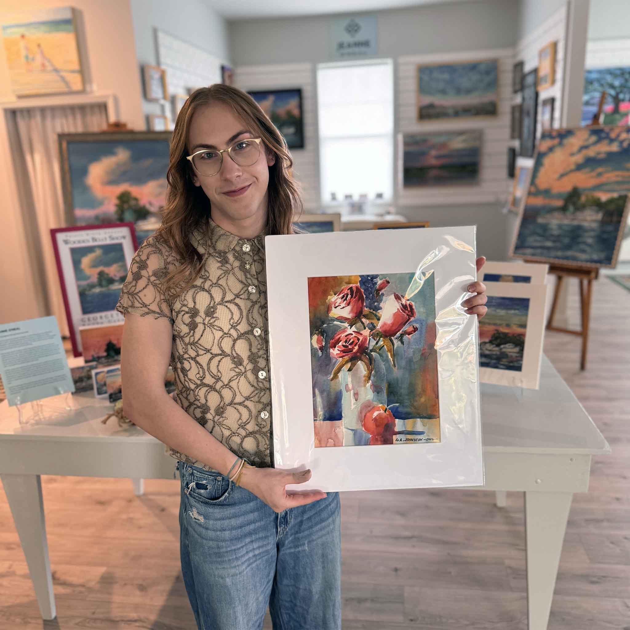Alex holding Roses by Gary Johnston at Gray Man Gallery in Pawleys Island, South Carolina. Original watercolor floral artwork featuring pink roses in a vase with expressive color and soft washes of light.