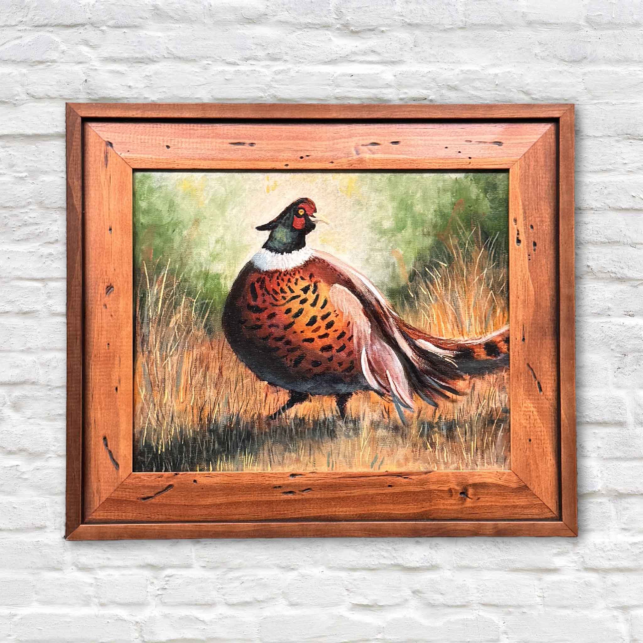 Birds of a Pheasant original oil wildlife painting by Jamie Arnold depicting a ring-necked pheasant with burnished copper, chestnut, and deep green plumage set against soft field grasses, framed in rustic wood and displayed at Gray Man Gallery in Pawleys Island, South Carolina