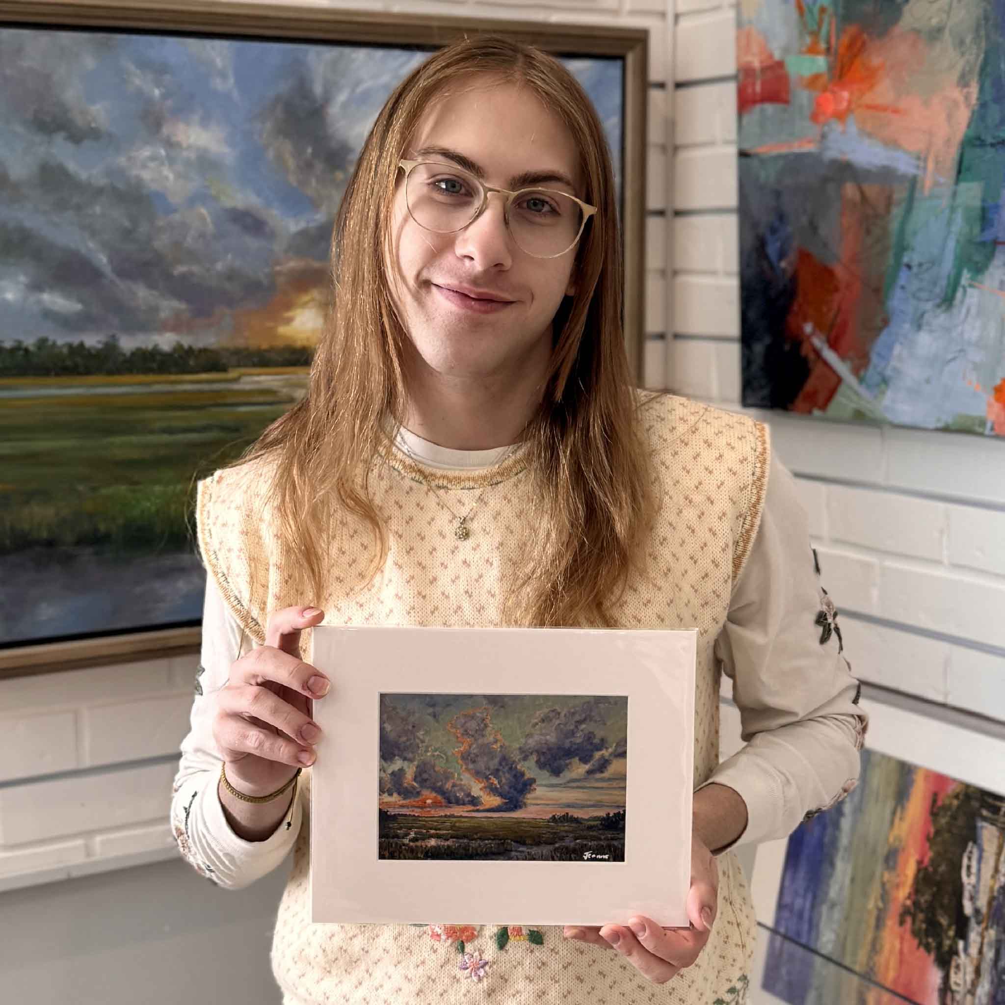 A Gray Man Gallery team member holds BAM!, an 8×10 matted giclée by Jeanne O’Neal, shown for scale inside the gallery.