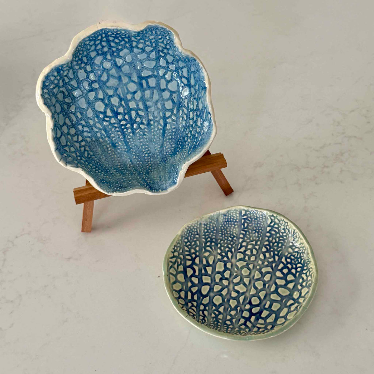 Handmade Coral Shell Dishes by Pawleys Island artist and Gray Man Gallery founder Vida Miller, featuring round and shell-shaped ceramic dishes with intricate coral-inspired texture and coastal blue and seafoam glazes, available at Gray Man Gallery in Pawleys Island, South Carolina