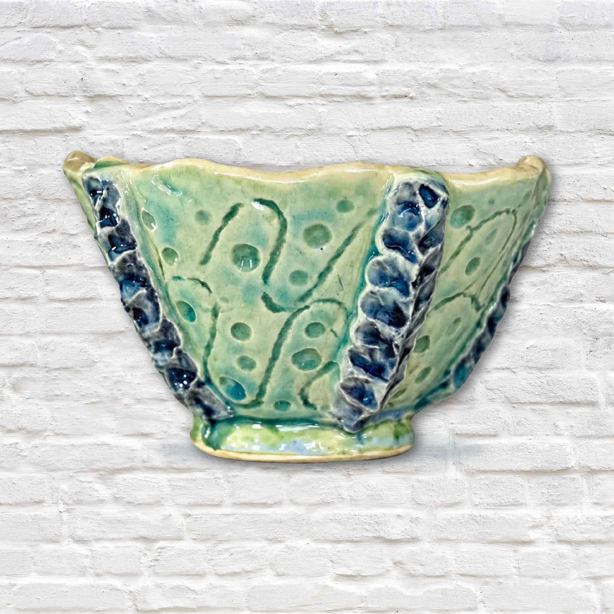Handmade Tidepool Texture Bowl by Pawleys Island artist and Gray Man Gallery founder Vida Miller, featuring a sculptural seafoam green ceramic exterior with organic impressions, raised deep blue details and a softly irregular rim inspired by coastal textures of the South Carolina Lowcountry.