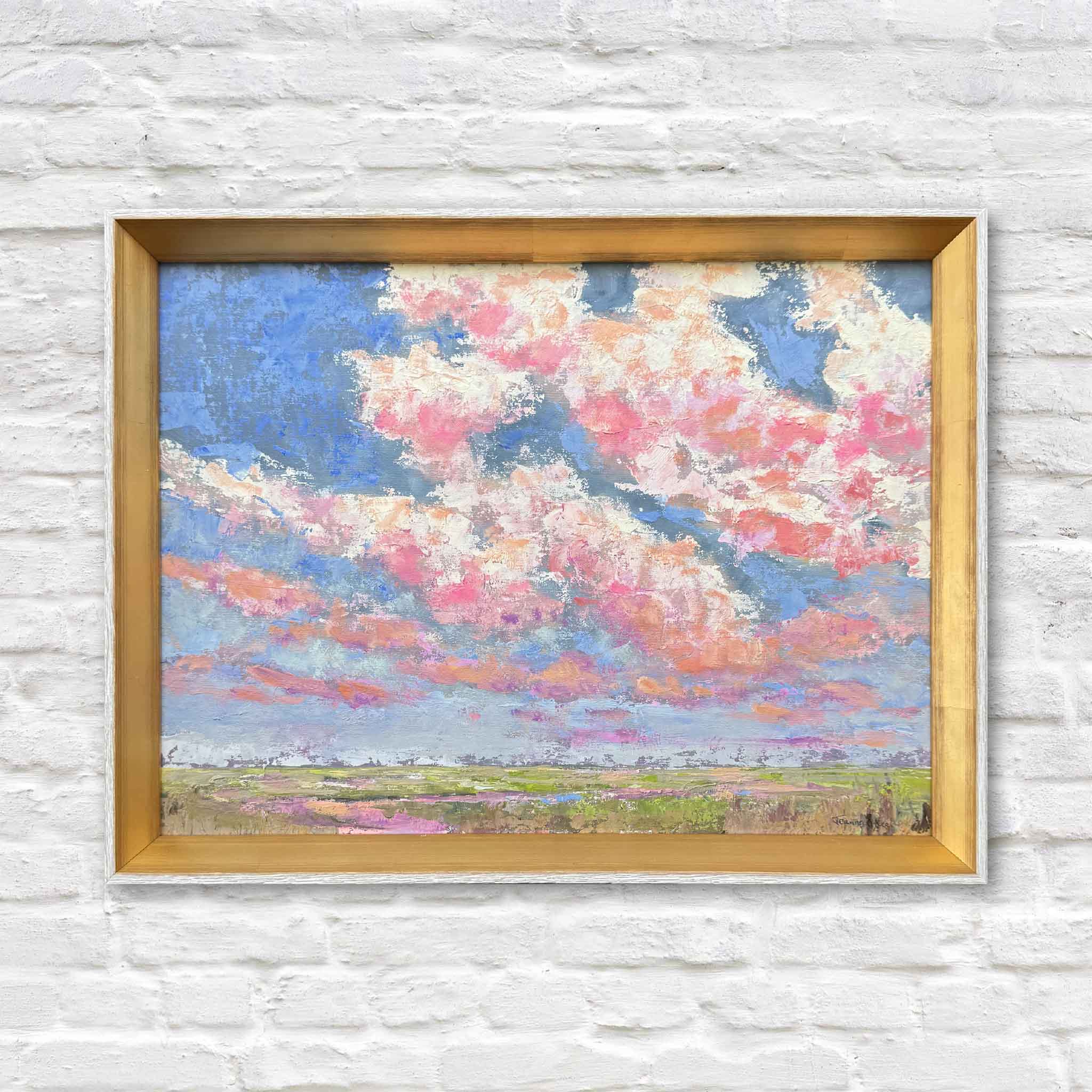 Beneath the Blushing Sky, an original Lowcountry oil painting by Pawleys Island artist Jeanne O’Neal, featuring dramatic pink, coral, peach and white sunset clouds against a brilliant blue sky above the South Carolina coastal marsh. Shown in O’Neal’s signature gold frame at Gray Man Gallery in Pawleys Island, this colorful original landscape painting captures the expansive skies, marsh grasses and changing evening light of the Lowcountry.