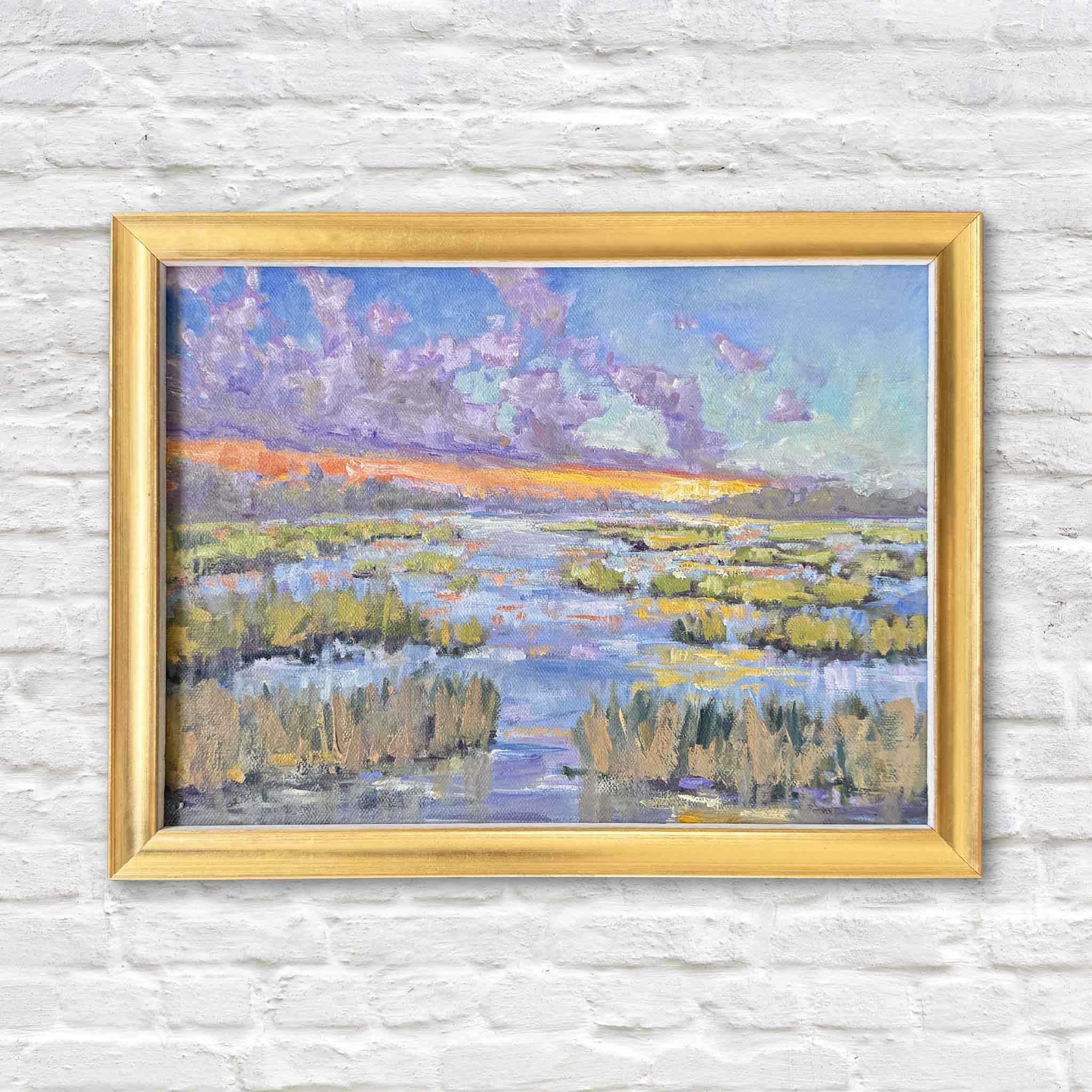 Daybreak original oil painting by South Carolina artist Jeanne O’Neal, featuring a colorful Lowcountry tidal marsh at sunrise with lavender clouds, glowing orange light, winding waterways and marsh grass, framed in gold at Gray Man Gallery in Pawleys Island.