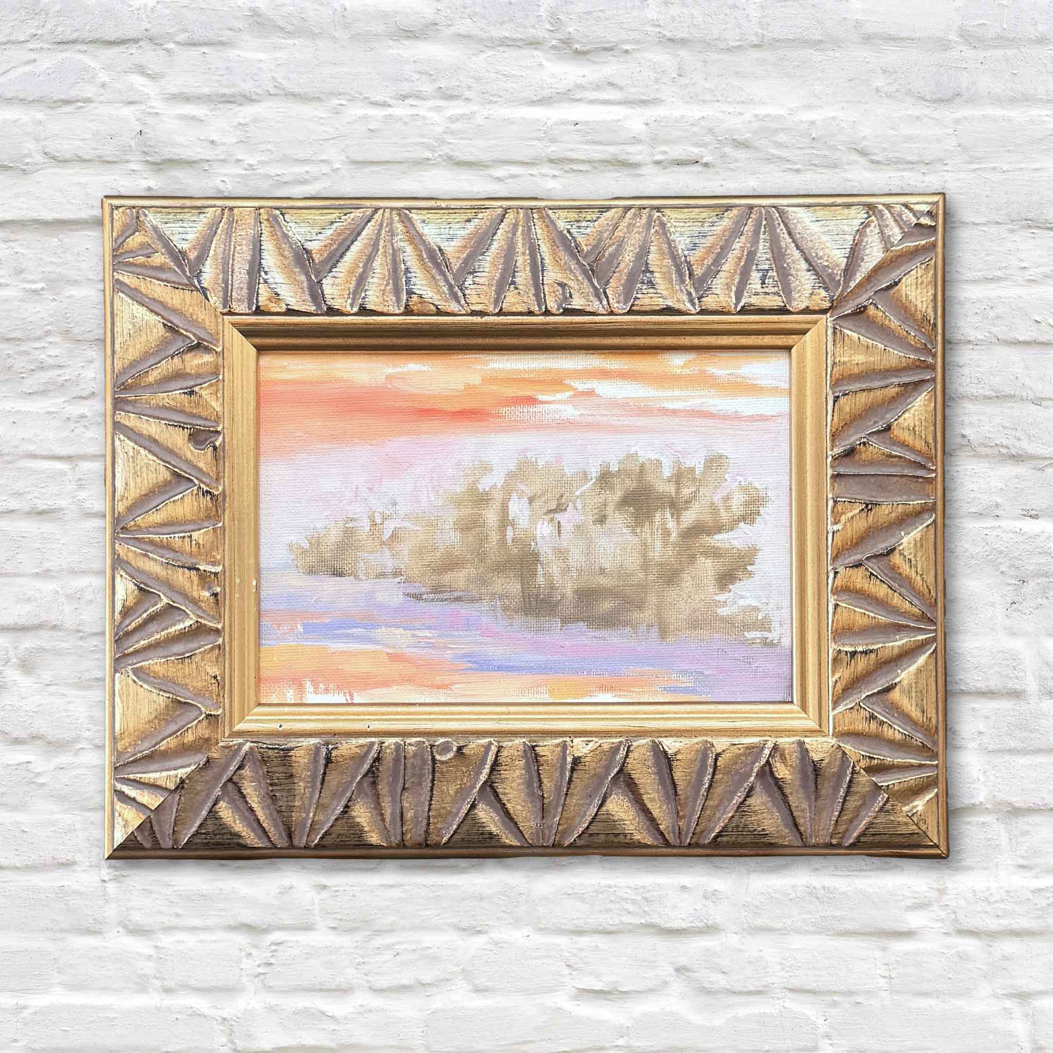 Jeanne O’Neal original oil painting Edge of the Tide featuring a soft Lowcountry coastal landscape with warm coral and peach sky, reflective water, and distant marsh trees, framed in a textured gold frame at Gray Man Gallery in Pawleys Island