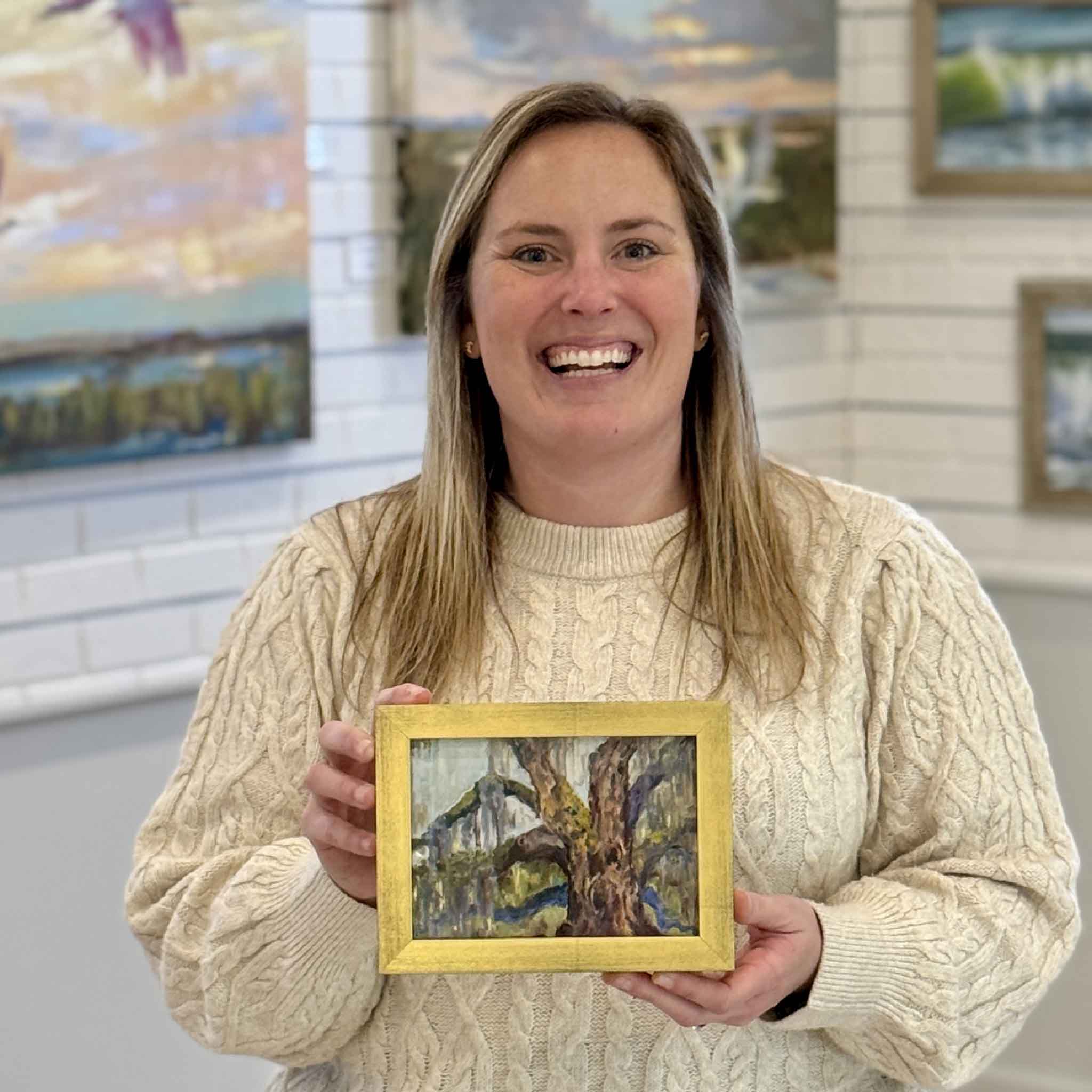 Bordy holding Graceful Rest by local artist Jeanne O’Neal a 7x5 framed live oak fine art print in Jeanne’s signature gold frame at Gray Man Gallery Pawleys Island