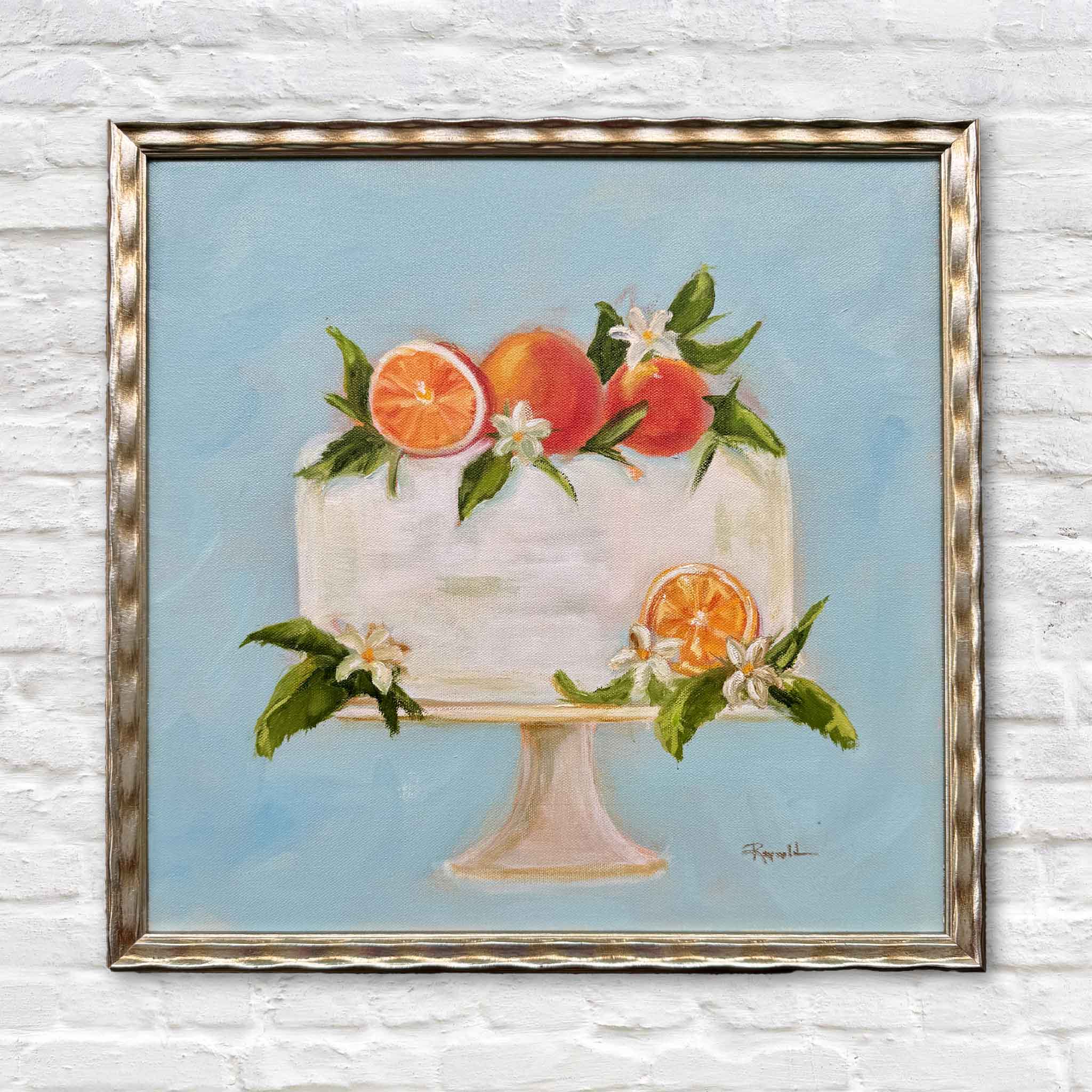 Creamsicle by local artist Jenny Reynolds is an original oil painting featuring a frosted citrus cake topped with oranges, blossoms, and greenery, framed in the artist’s signature champagne frame at Gray Man Gallery in Pawleys Island