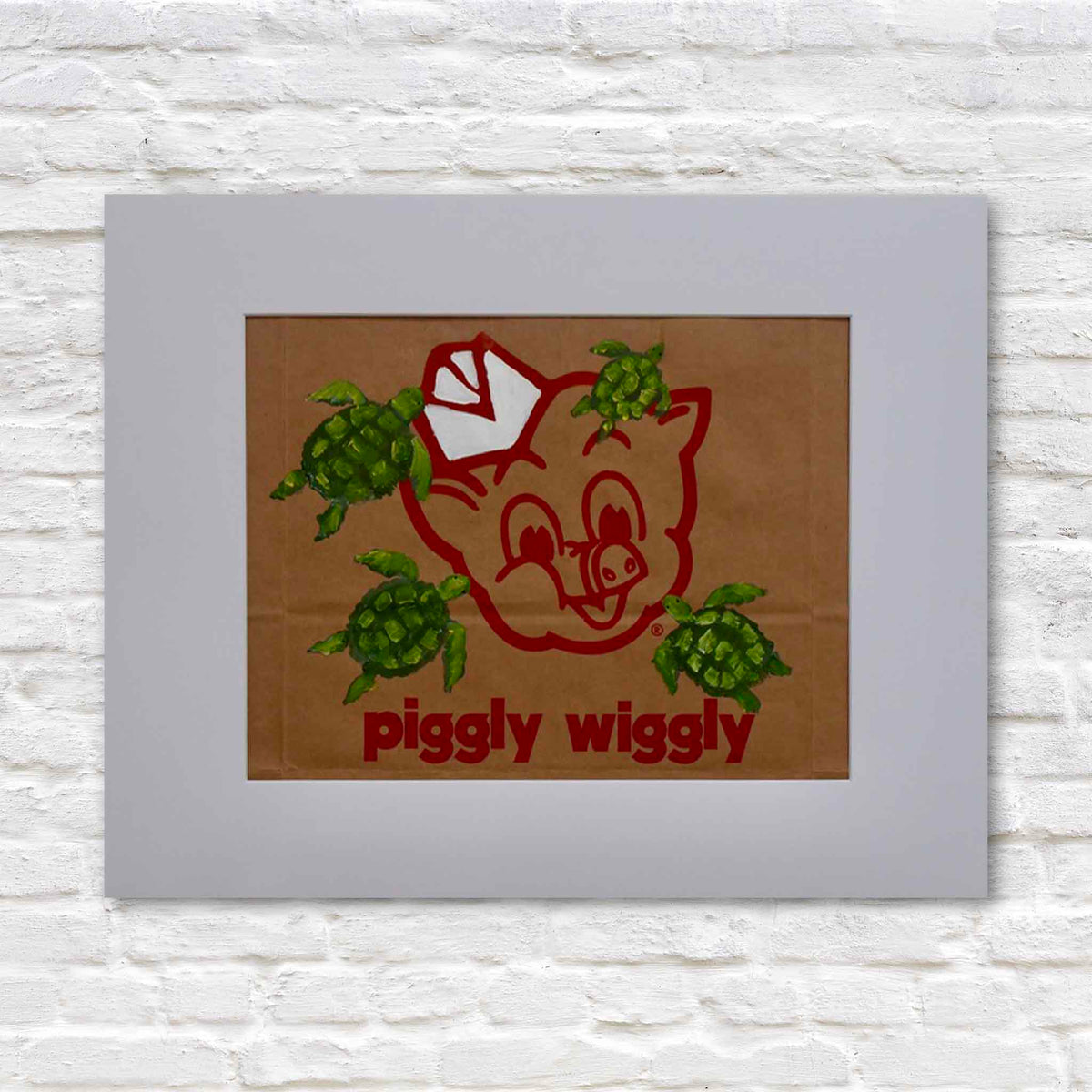 The Great Escape, original acrylic painting by local artist Jenny Reynolds featuring four green sea turtles swimming across the iconic red Piggly Wiggly mascot on a genuine brown paper grocery bag. Presented in a wide white mat at Gray Man Gallery in Pawleys Island, South Carolina.