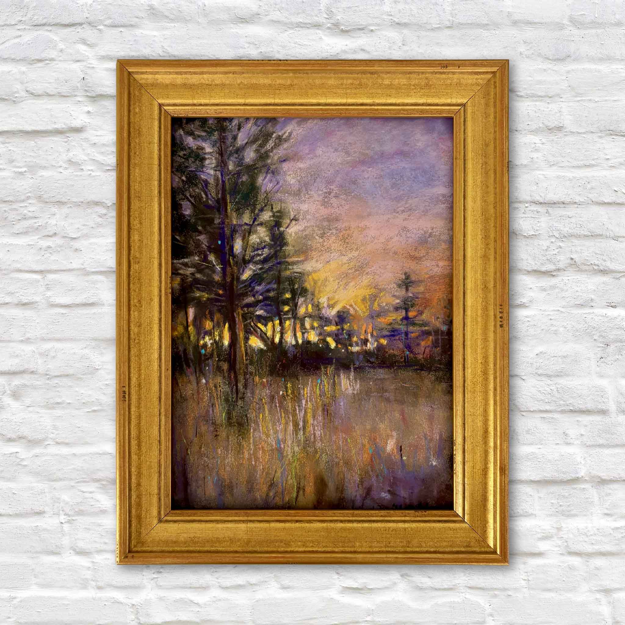 Forest of Dreams, an original pastel landscape painting by Joanne Willoughby, features a dreamy woodland scene at dusk with glowing golden light, violet skies, dark trees and reflections across still water, shown framed at Gray Man Gallery in Pawleys Island, South Carolina.