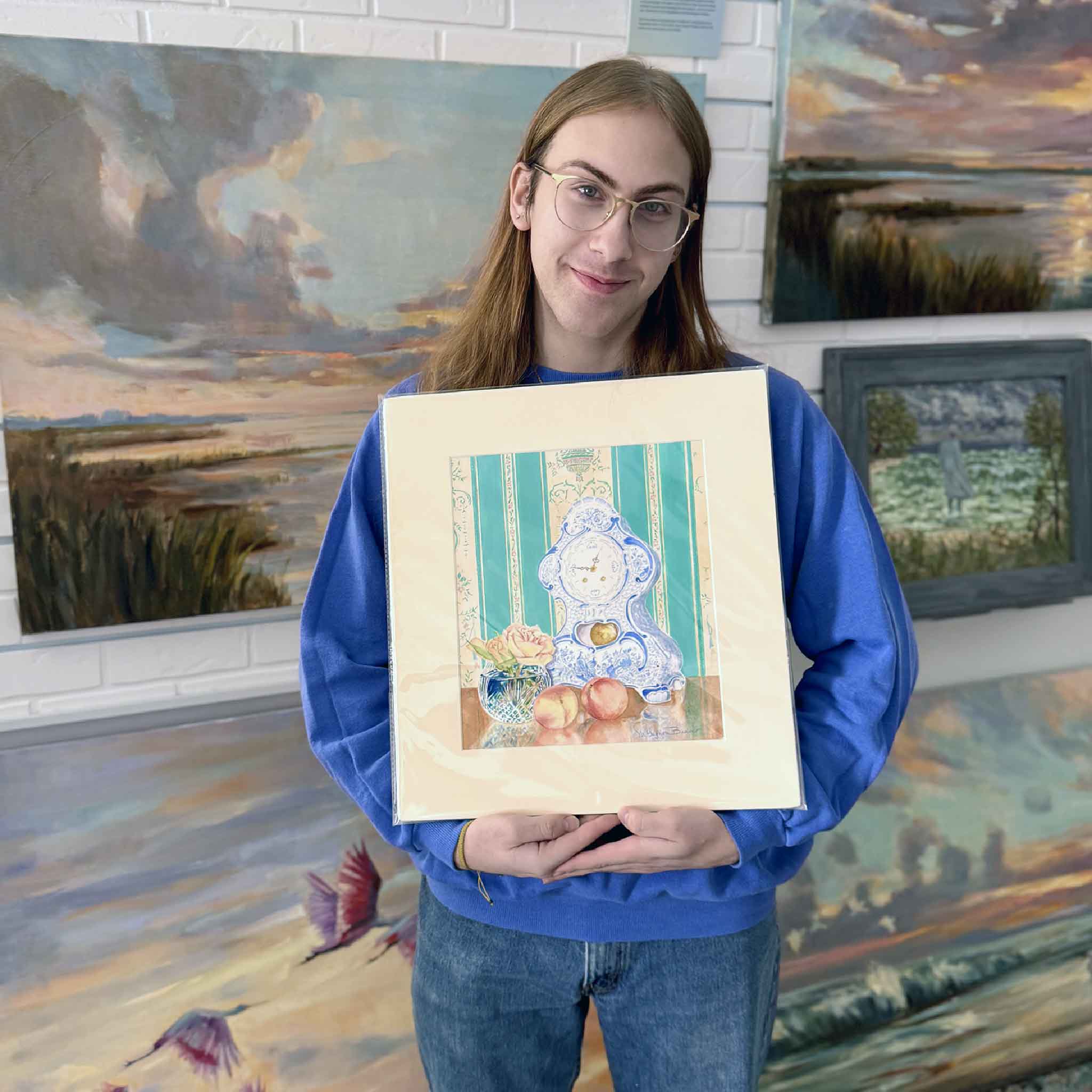 A Gray Man Gallery team member holds Just Peachy by Mimi Beaver, an original watercolor artwork donated to support Salty Dogs Senior Animal Rescue, with all proceeds benefiting senior dogs.