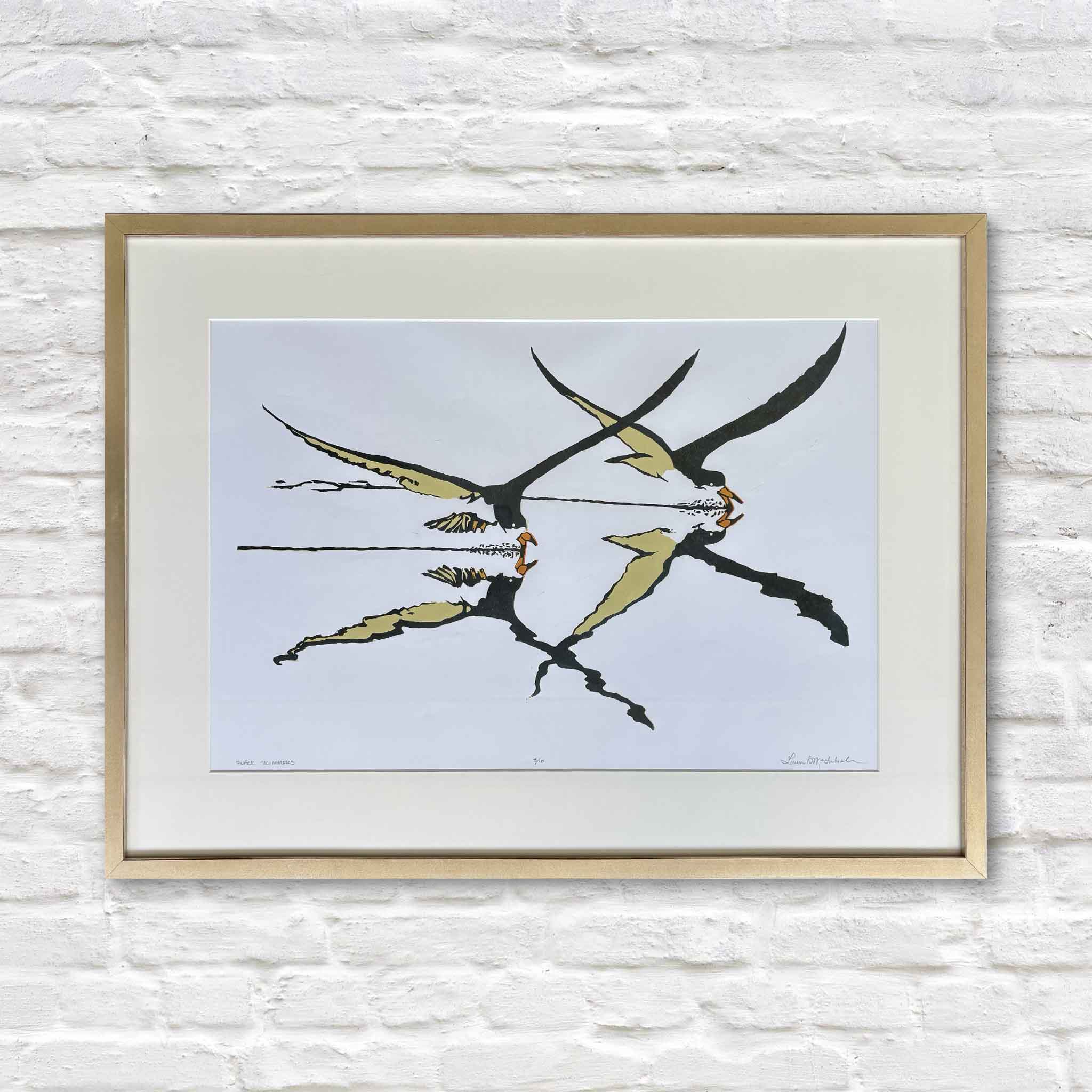 Black Skimmers by Laurie Brownell McIntosh, an original reduction linocut featuring two black skimmers flying low over the water with mirrored reflections, professionally matted and framed at Gray Man Gallery in Pawleys Island, South Carolina.