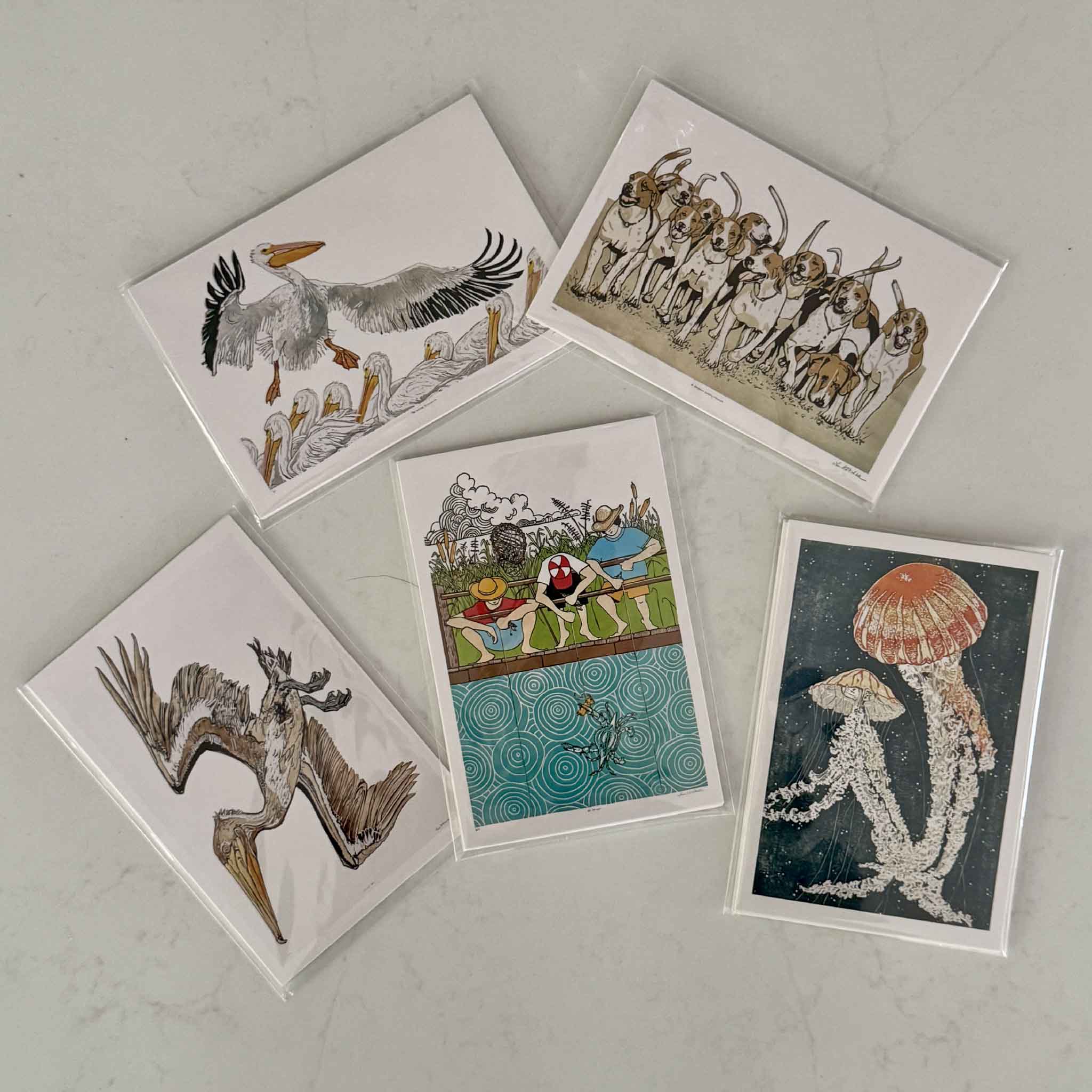 Five assorted fine art postcards by Laurie McIntosh featuring Jelly Dance, White Pelicans, A Dozen Happy Hounds, a heron artwork, and a colorful coastal fishing scene. Part of the Coastal Postcard Collection available at Gray Man Gallery in Pawleys Island, South Carolina.