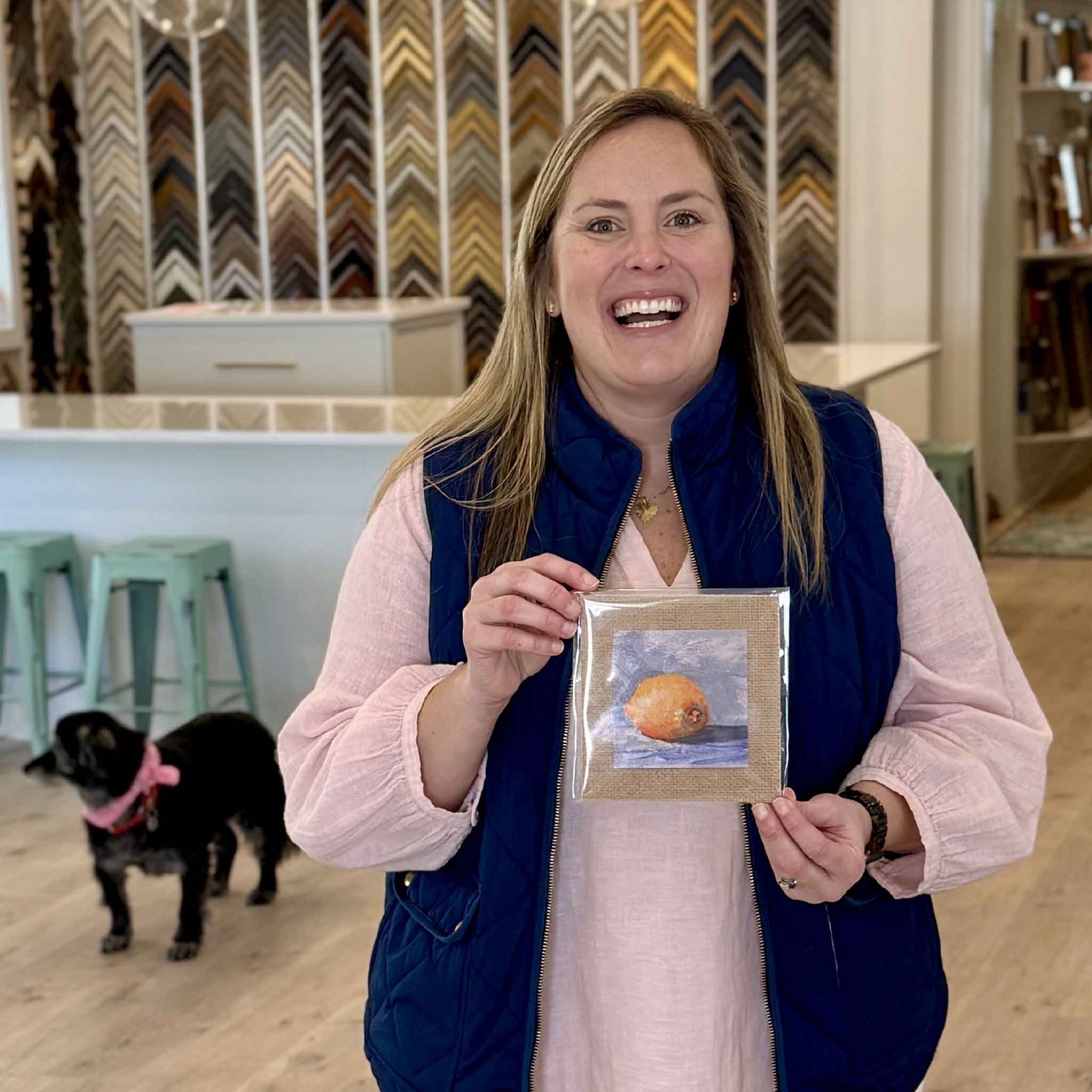 Bordy holding Lemon Drop fine art giclée print by local South Carolina artist Jeanne O’Neal at Gray Man Gallery in Pawleys Island, 4x4 lemon artwork mounted on 6x6 burlap mat, small giftable Lowcountry coastal art piece with warm citrus colors and textured presentation