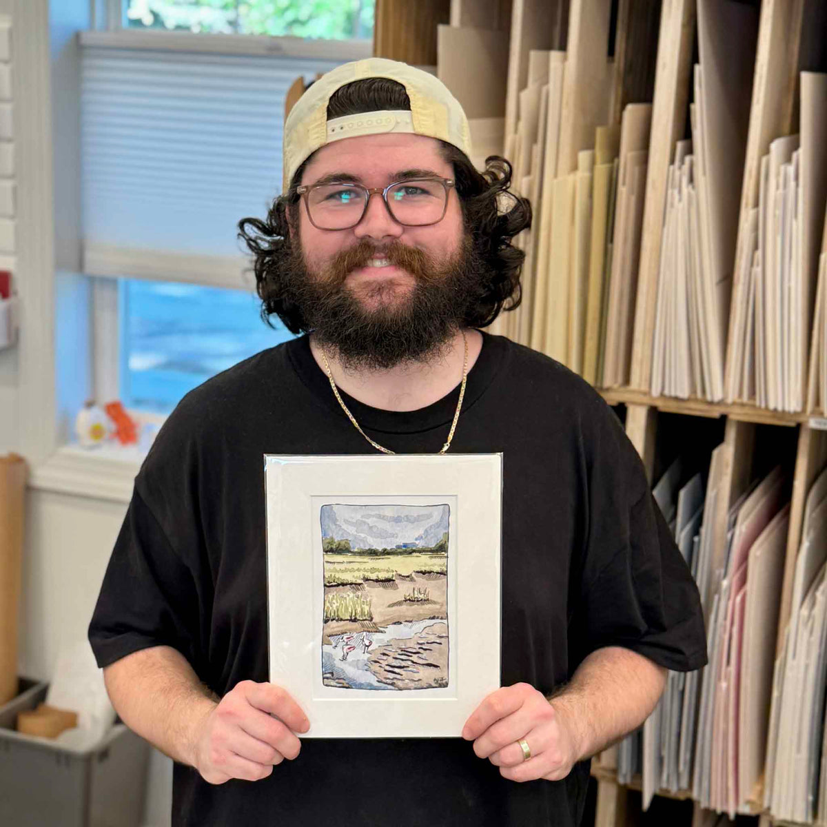 Peyton holding an 8x10 matted Following the Tide fine art giclée print by South Carolina artist Maggie Pelton, featuring roseate spoonbills in a Lowcountry tidal marsh, available at Gray Man Gallery in Pawleys Island, SC.