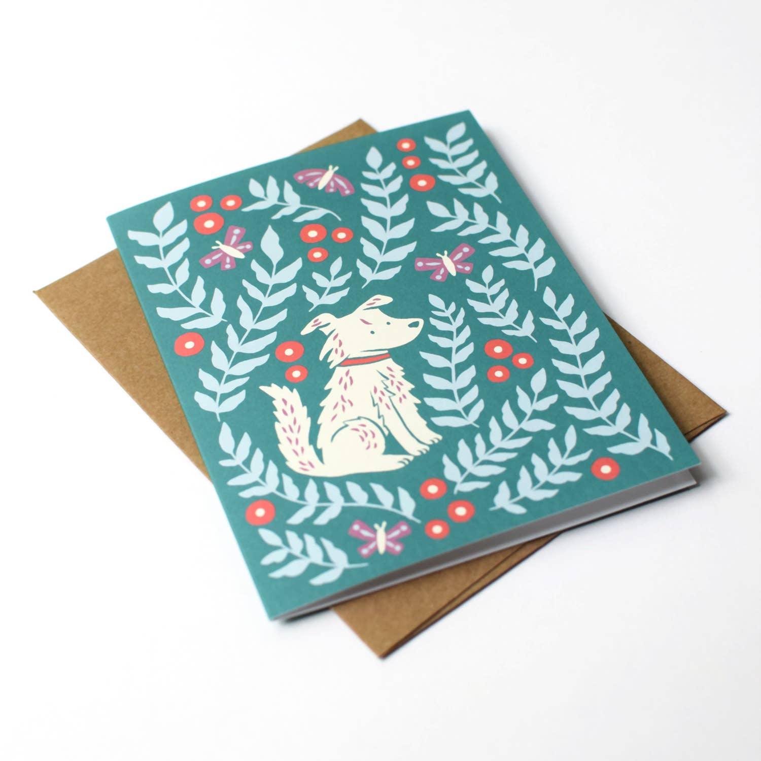 Open view of the Molly Meadows greeting card by Chrissie Van Hoever displayed with its recycled kraft envelope, highlighting the premium recycled cardstock and whimsical botanical dog illustration available at Gray Man Gallery in Pawleys Island, South Carolina.