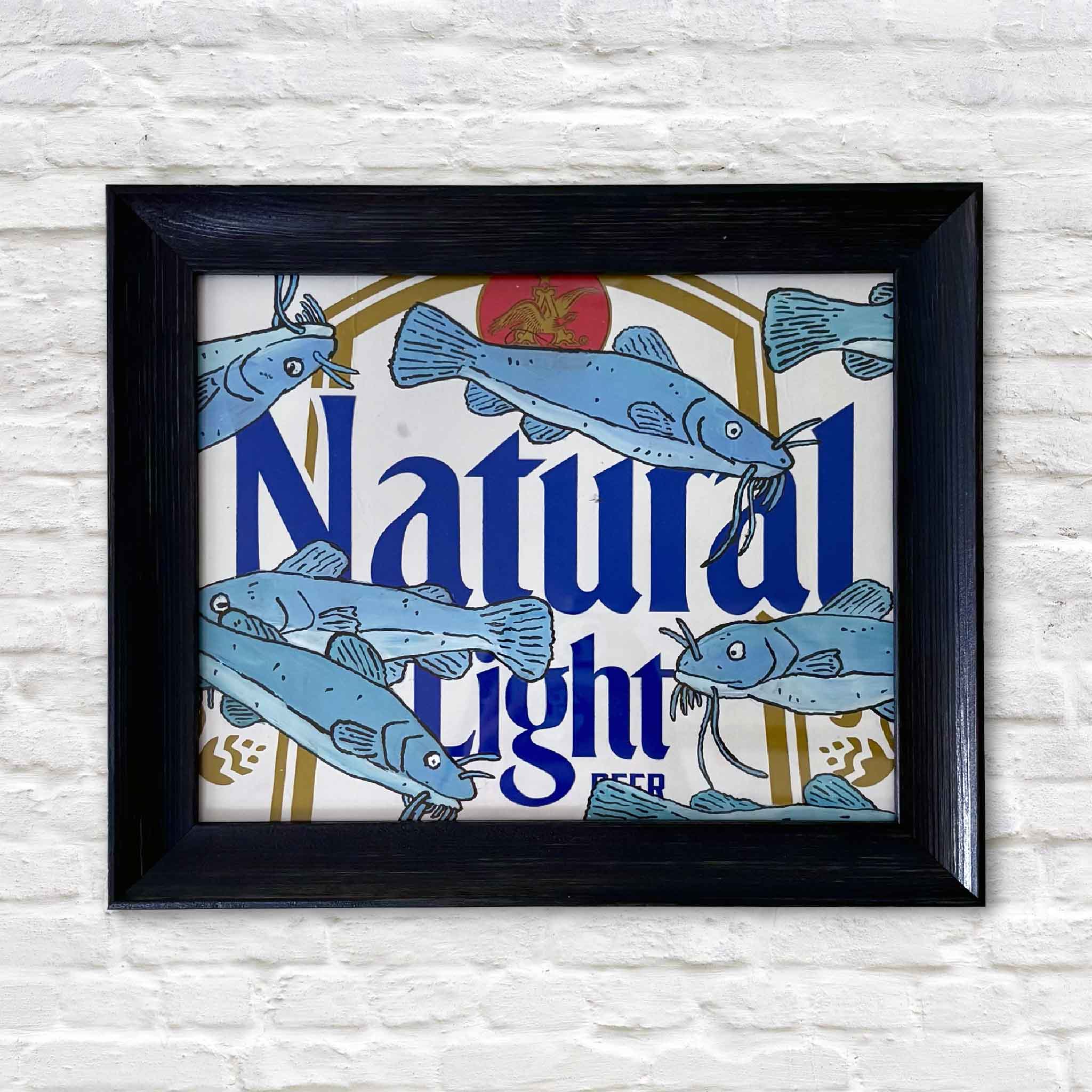 Catties 'n Nattys by Charleston artist Nick Kawczynski features hand-painted catfish on a reclaimed Natural Light beer box. This original mixed media artwork is professionally framed in navy blue and available at Gray Man Gallery in Pawleys Island, South Carolina.
