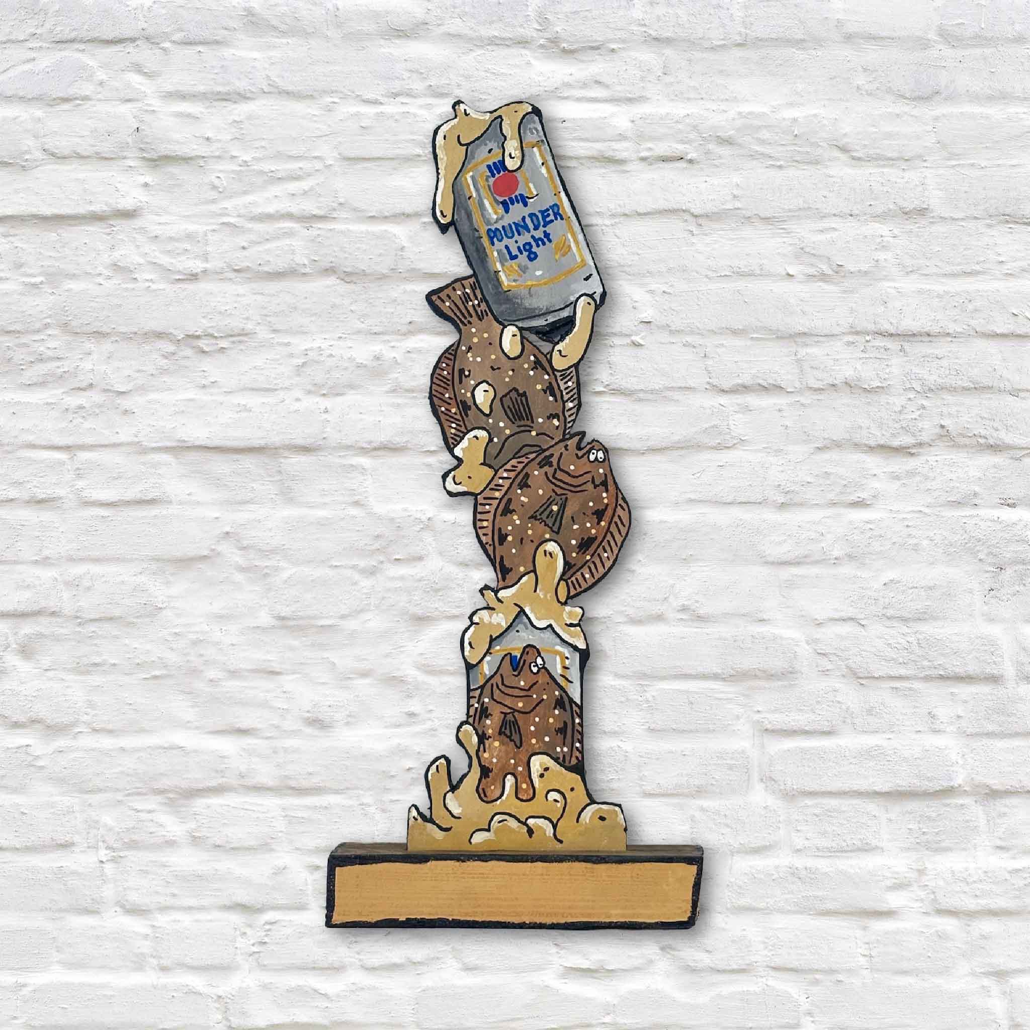 Poundahs 'n Floundahs, a one-of-a-kind mixed media sculpture by Charleston artist Nick Kawczynski featuring hand-painted flounder climbing a whimsical Pounder Light beer can. Crafted from reclaimed marine-grade plywood salvaged through the Lowcountry Maritime Society boatbuilding program and available exclusively at Gray Man Gallery in Pawleys Island, South Carolina.