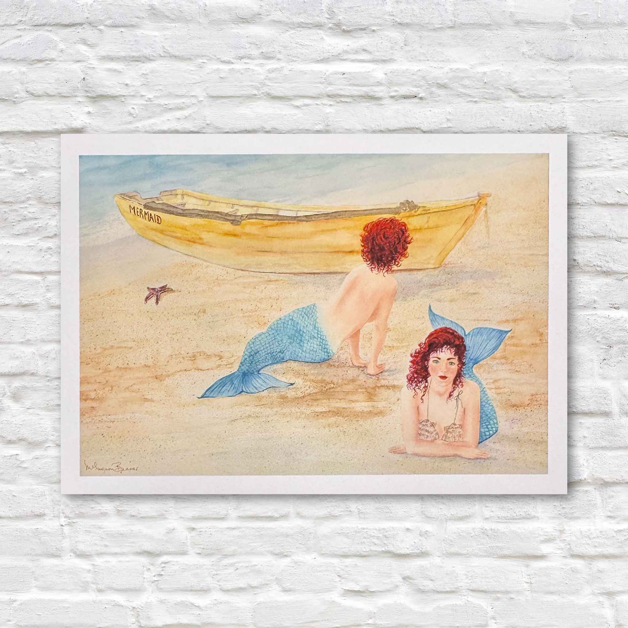 Print of Mimi Beaver’s watercolor featuring two red-haired mermaids on a sandy beach near a yellow boat named Mermaid, donated to support senior dogs.