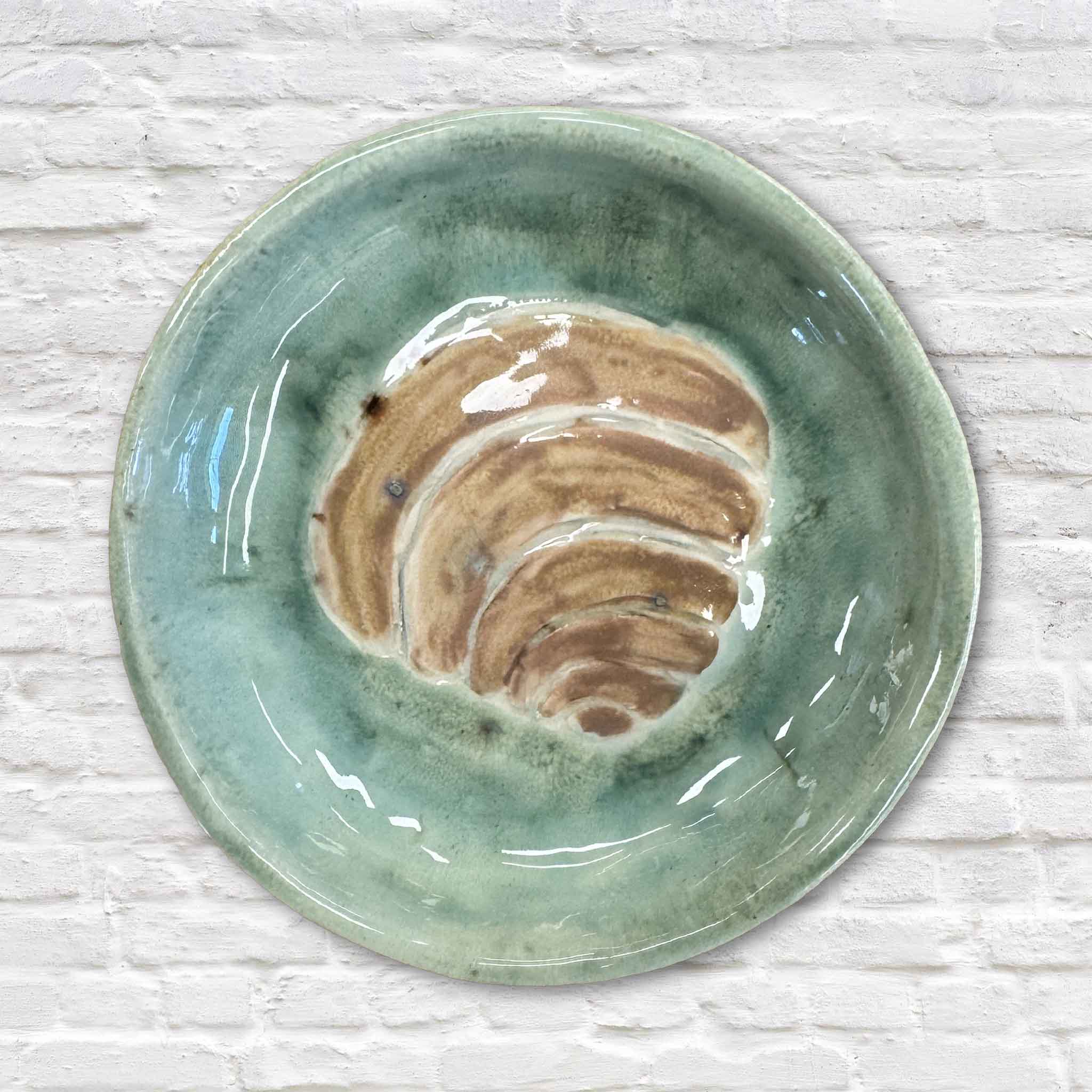 Handmade green ceramic Pawleys Island shell dish by local artist Vida Miller at Gray Man Gallery featuring a carved shell design and glossy coastal glaze