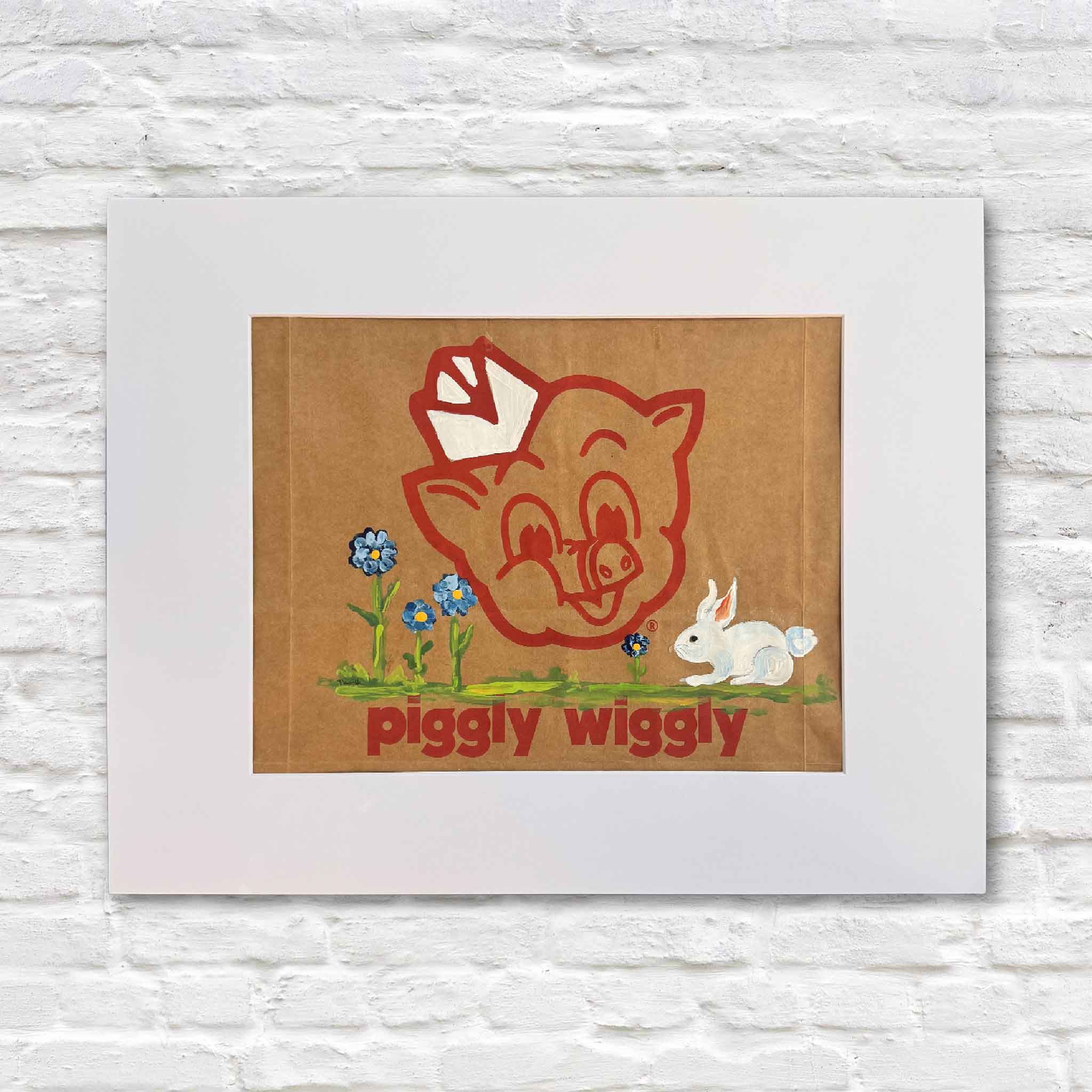 Original hand-painted artwork on a real Piggly Wiggly grocery bag by local artist Jenny Reynolds, featuring the iconic pig mascot with blue wildflowers and a white bunny, matted to fit a standard 16x20 frame, available at Gray Man Gallery in Pawleys Island, South Carolina.